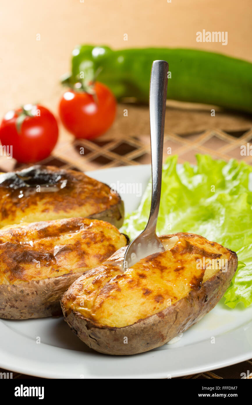 baked potatoes whole in their skins Stock Photo