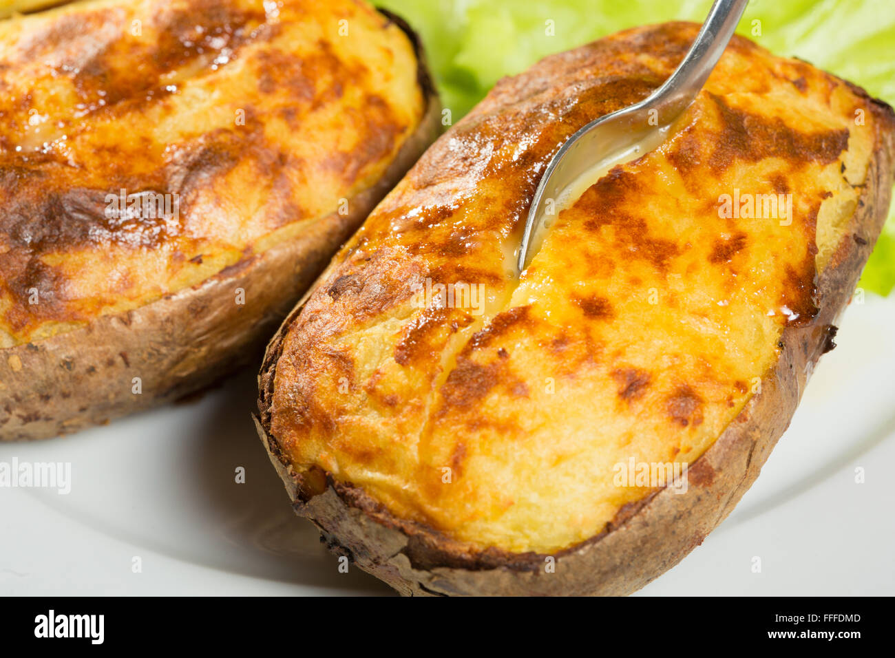 baked potatoes whole in their skins Stock Photo