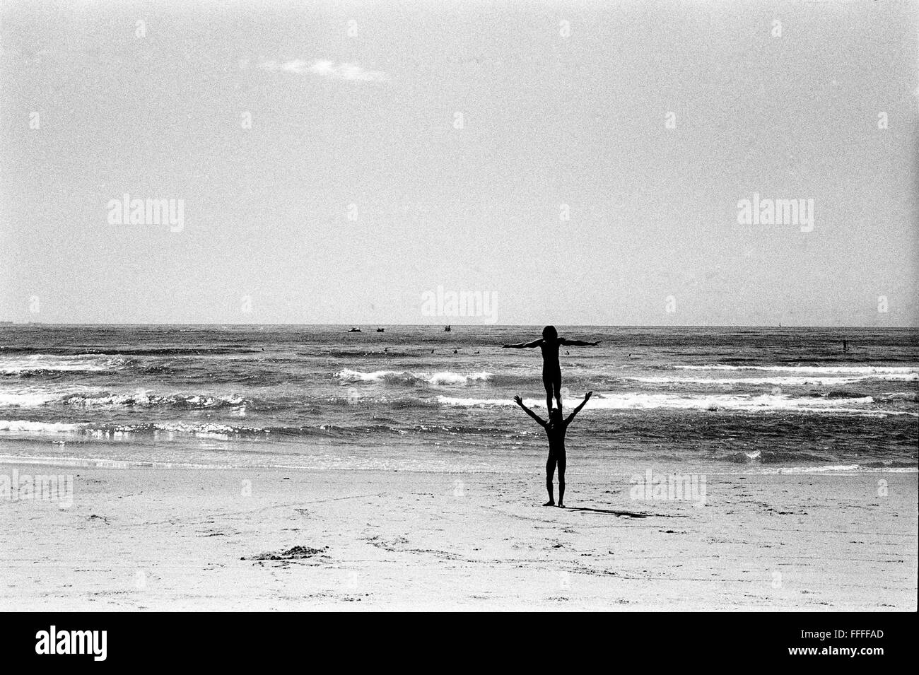 Jan 4, 2016 - South Beach, KwaZulu-Natal, South Africa - Two acrobats from Tanzania who are on their way to a better life in Europe, say that the beach is a good place to practice their craft and have a wash. South Beach is a part of the City of Durban's longest uninterrupted stretch of beach sand. The City of Durban is on the eastern seaboard of South Africa and the people here are washed with the warm waters of the Indian Ocean. To the north of this stretch of sand are beaches with cafe society hang outs. To the south there is a pier with the upmarket Moyo's Restaurant at it's end and the uS Stock Photo