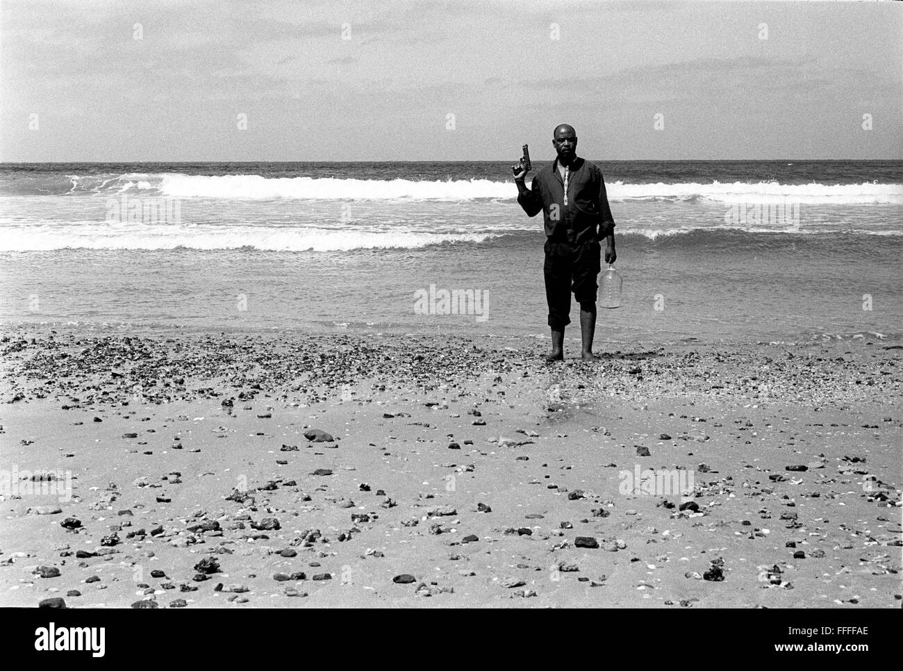 Jan 4, 2016 - South Beach, KwaZulu-Natal, South Africa - A pistol packing pastor collects water for the preying needs of his church. South Beach is a part of the City of Durban's longest uninterrupted stretch of beach sand. The City of Durban is on the eastern seaboard of South Africa and the people here are washed with the warm waters of the Indian Ocean. To the north of this stretch of sand are beaches with cafe society hang outs. To the south there is a pier with the upmarket Moyo's Restaurant at it's end and the uShaka Marine World complex and the private surf and sea clubs of the Vetches Stock Photo