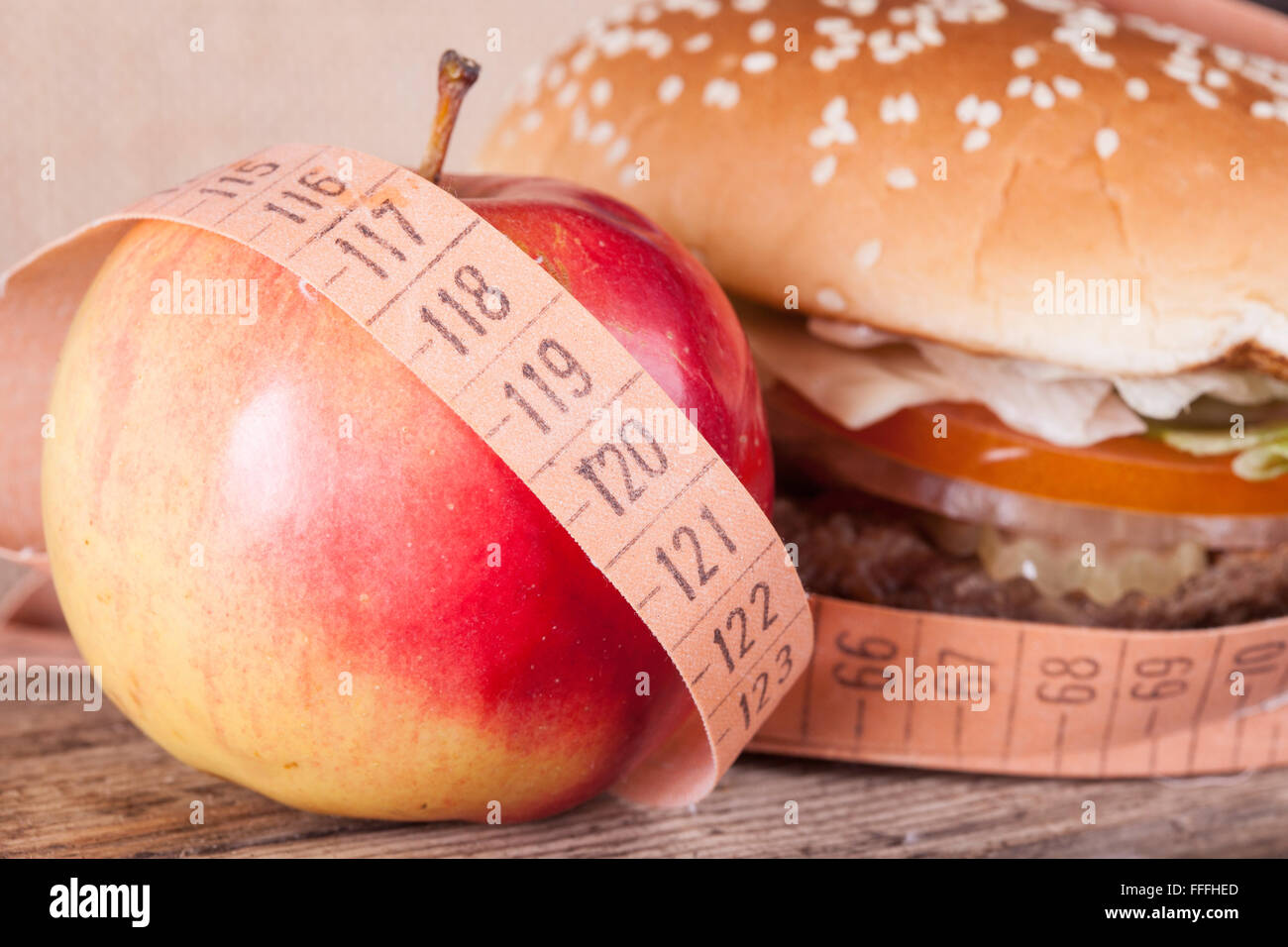 hamburger and apple with meter closeup. diet concept Stock Photo
