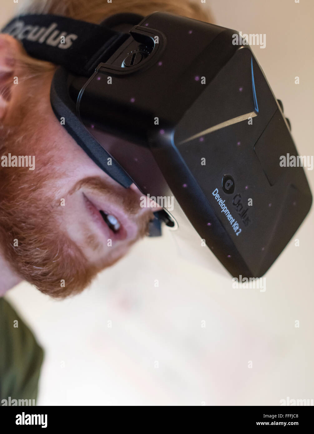A man (Caucasian ethnicity) is wearing Oculus Rift Development Kit 2 (DK2) virtual reality goggles while playing a computer game Stock Photo