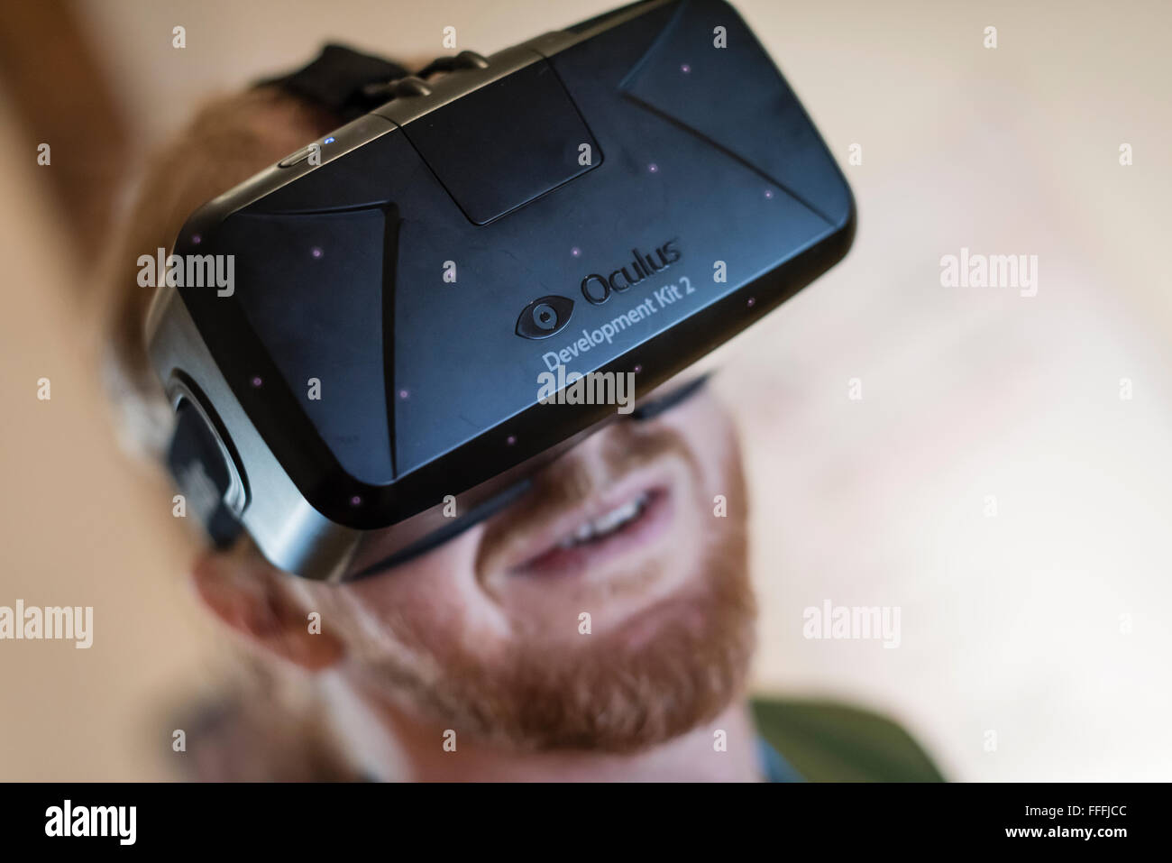 A man (Caucasian ethnicity) is wearing Oculus Rift Development Kit 2 (DK2) virtual reality goggles while playing a computer game Stock Photo