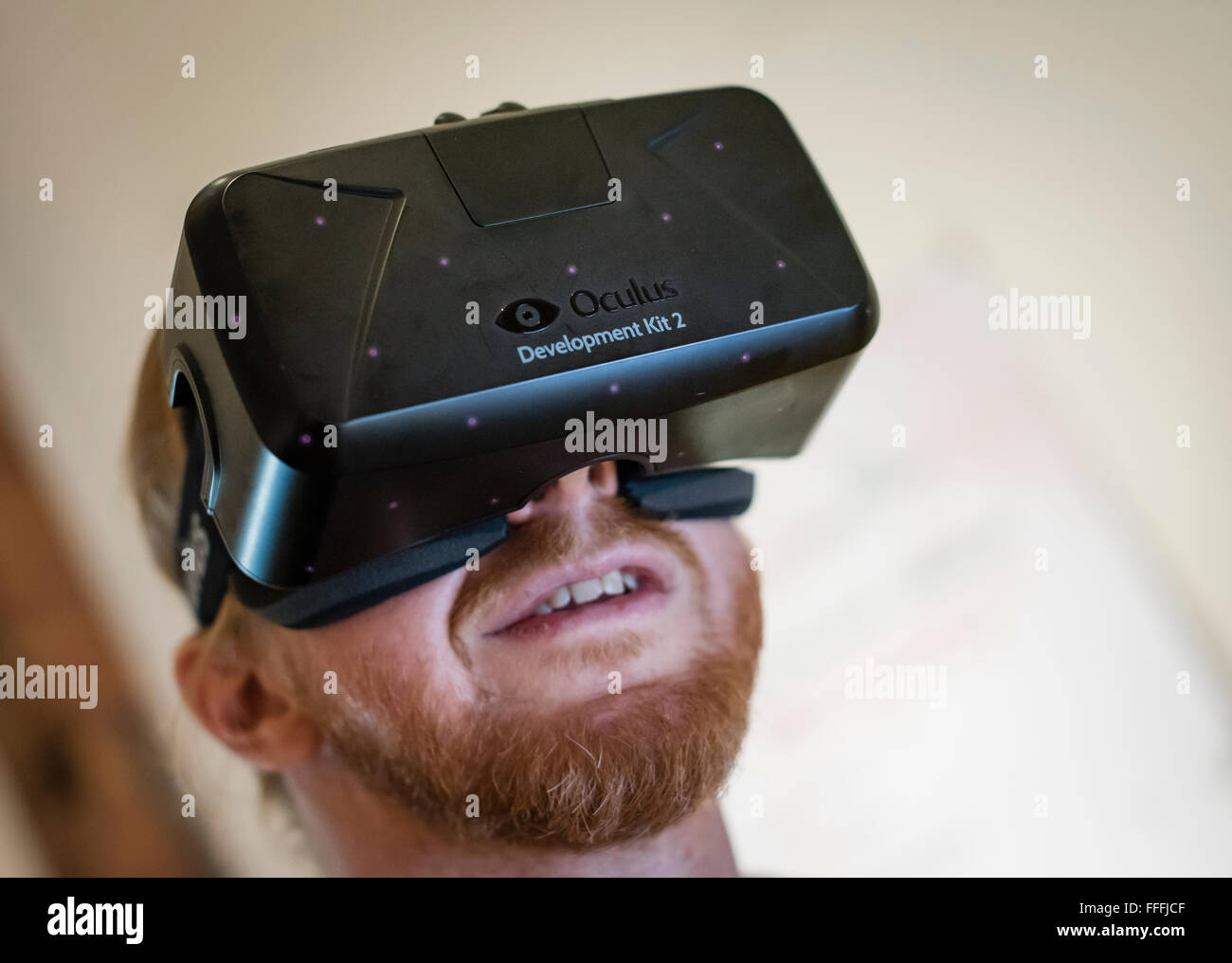 A man (Caucasian ethnicity) is wearing Oculus Rift Development Kit 2 (DK2) virtual reality goggles while playing a computer game Stock Photo