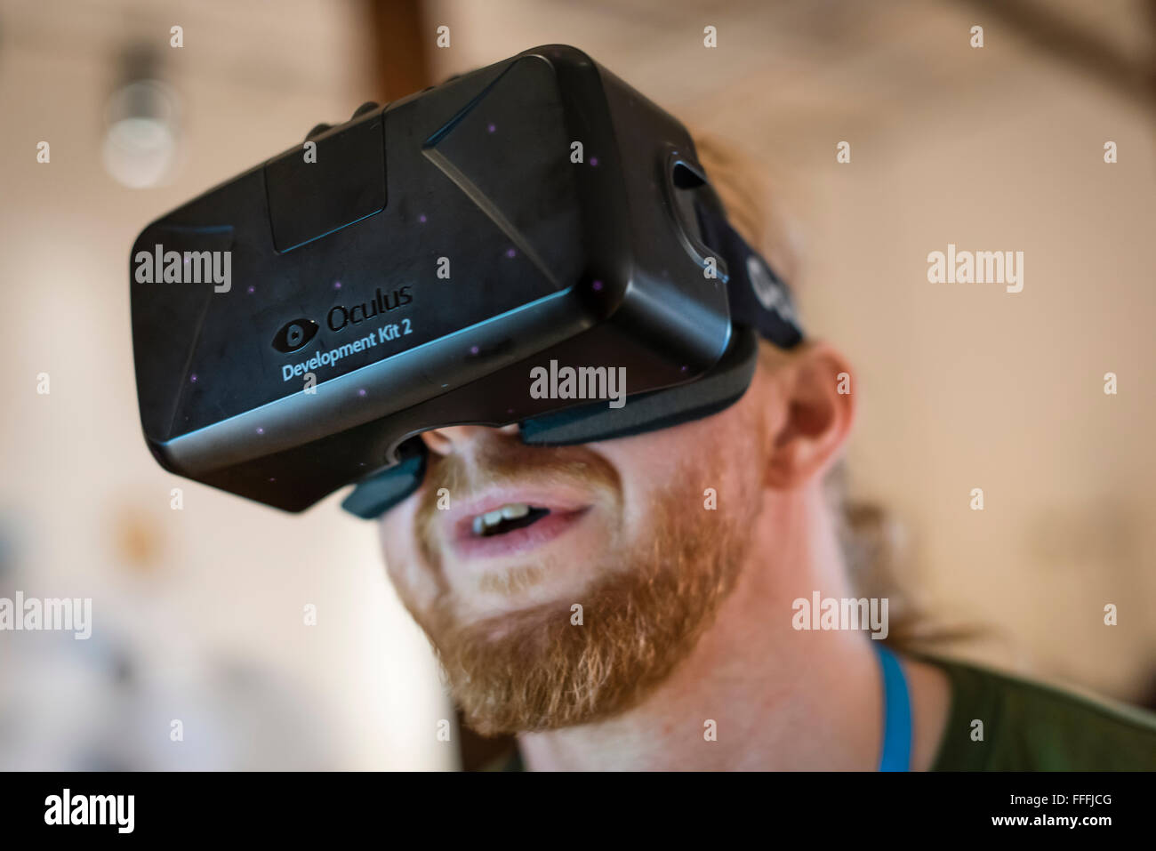 A man (Caucasian ethnicity) is wearing Oculus Rift Development Kit 2 (DK2) virtual reality goggles while playing a computer game Stock Photo