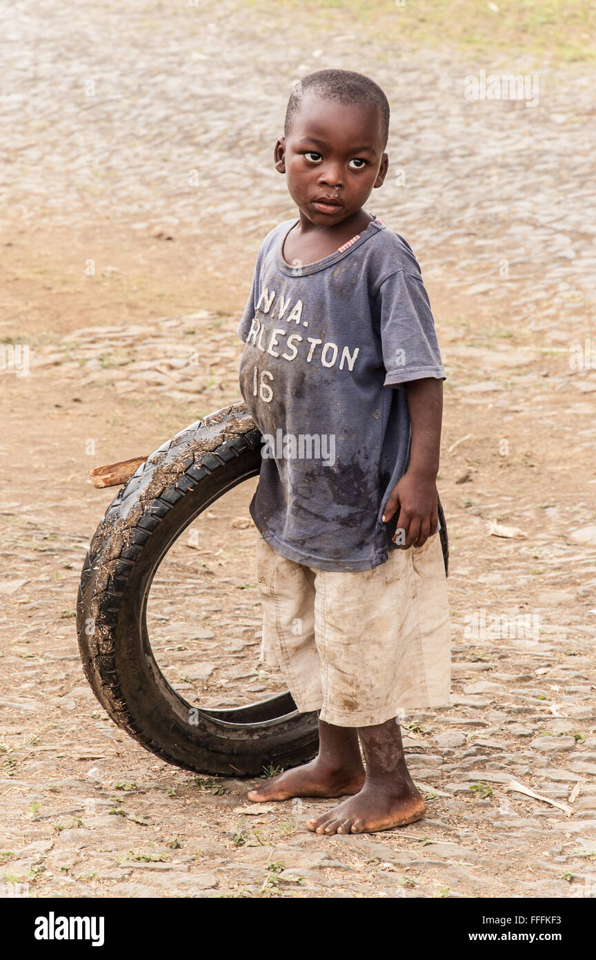 A little boy playing with a used car tyre in the roads of Guadalupe. Stock Photo