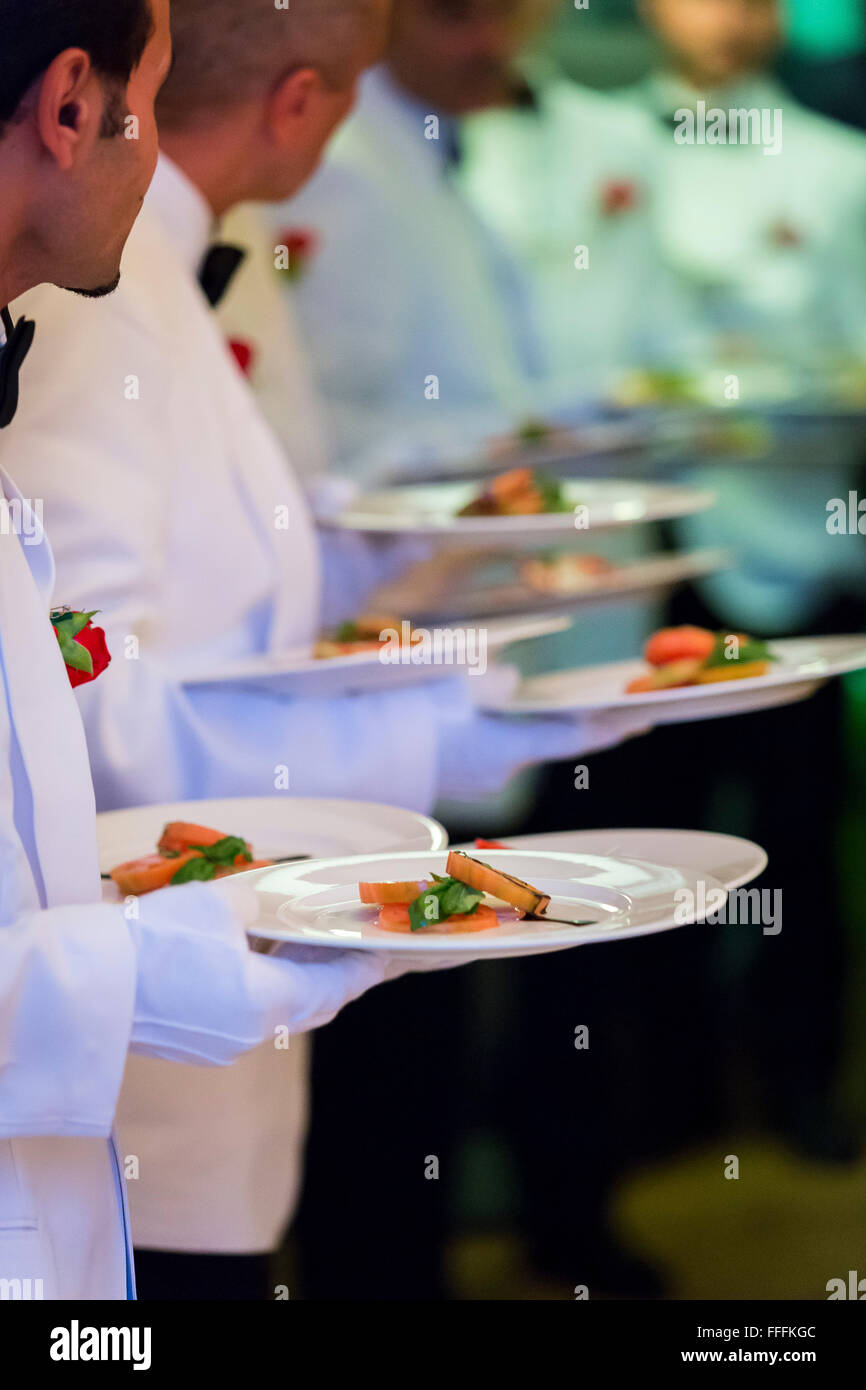 Lined up waiters with plates Stock Photo