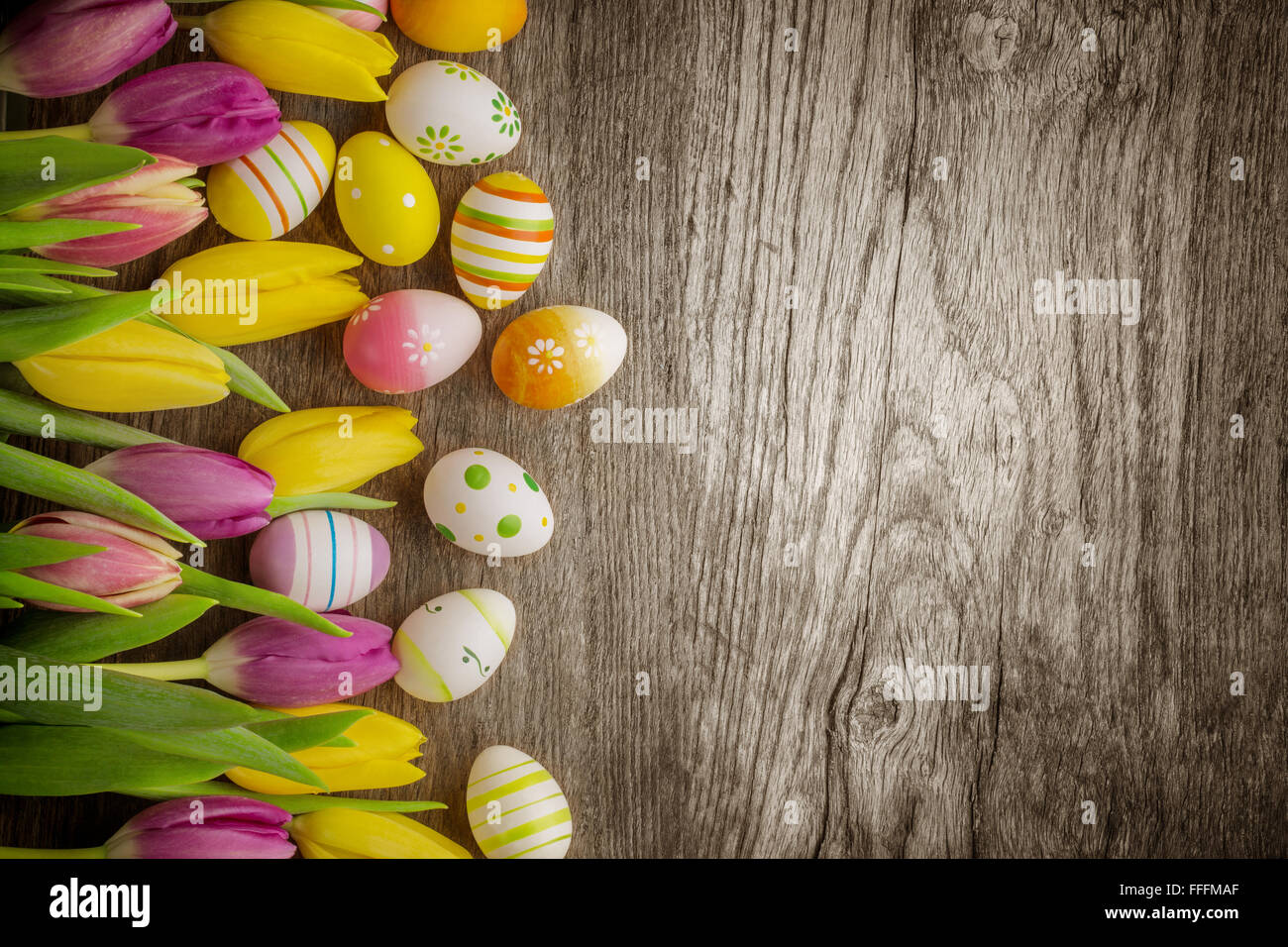 Tulips and easter eggs on rustic wood background Stock Photo - Alamy