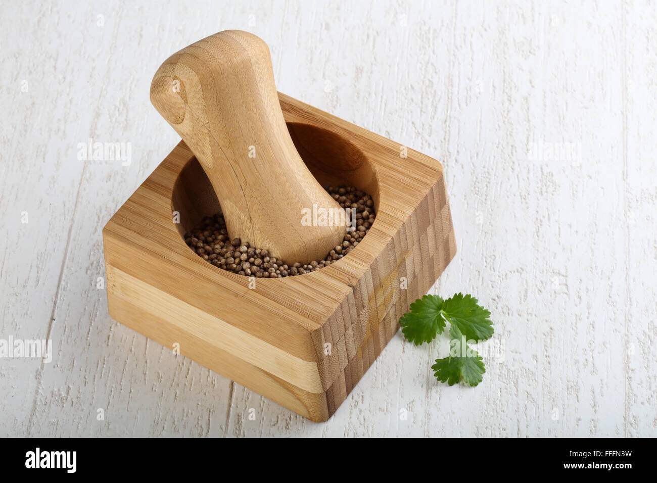 Mortar with coriander on the wood background Stock Photo