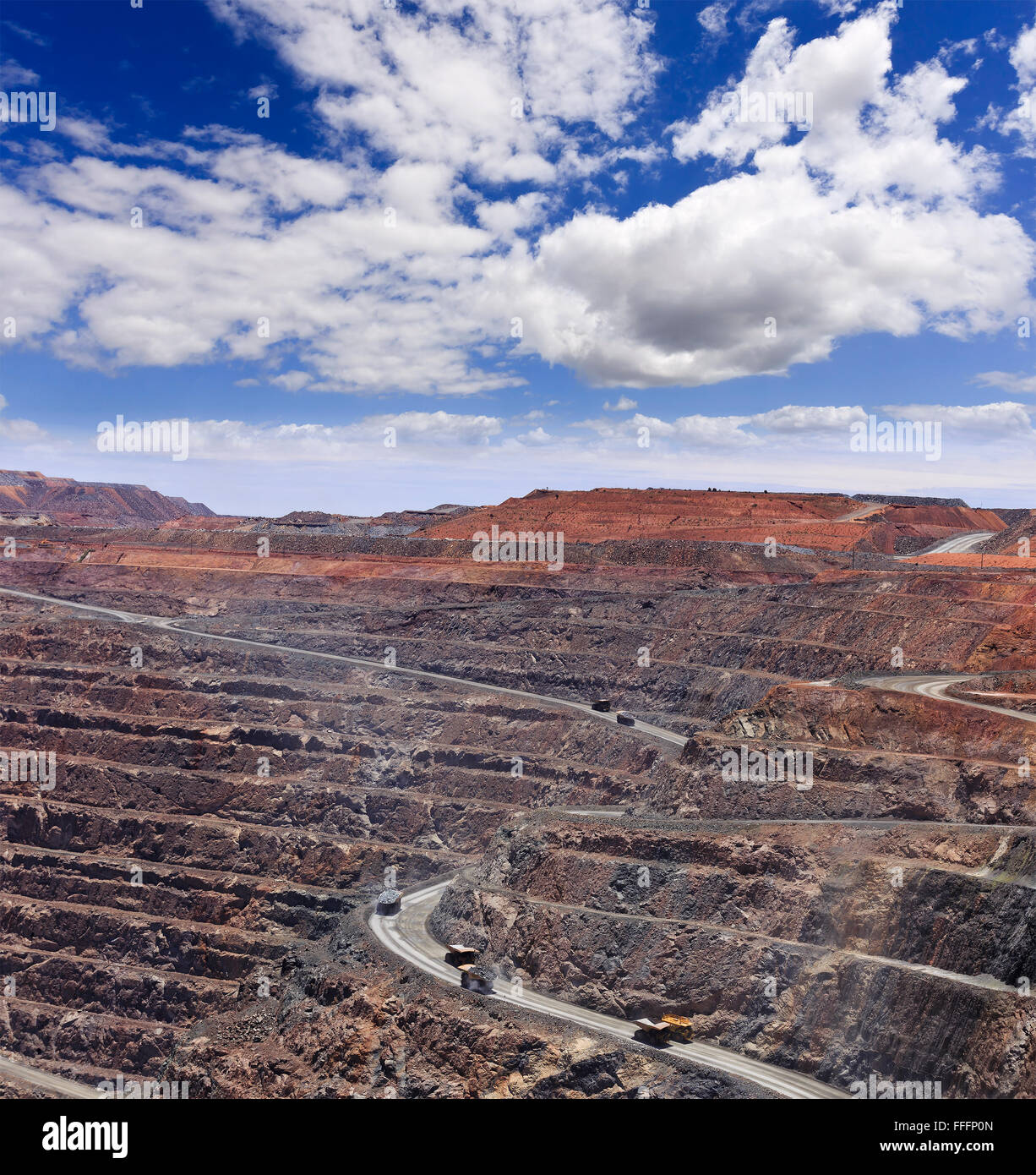 deep open gold mine - super pit, in Kalgoorlie Boulder, Western Australia. Layers of mine hole with huge trucks carrying loads o Stock Photo
