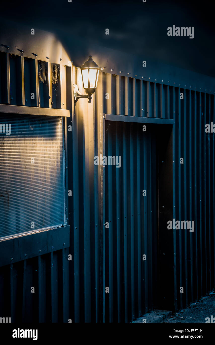 Light on a steel outbuilding at night. Stock Photo