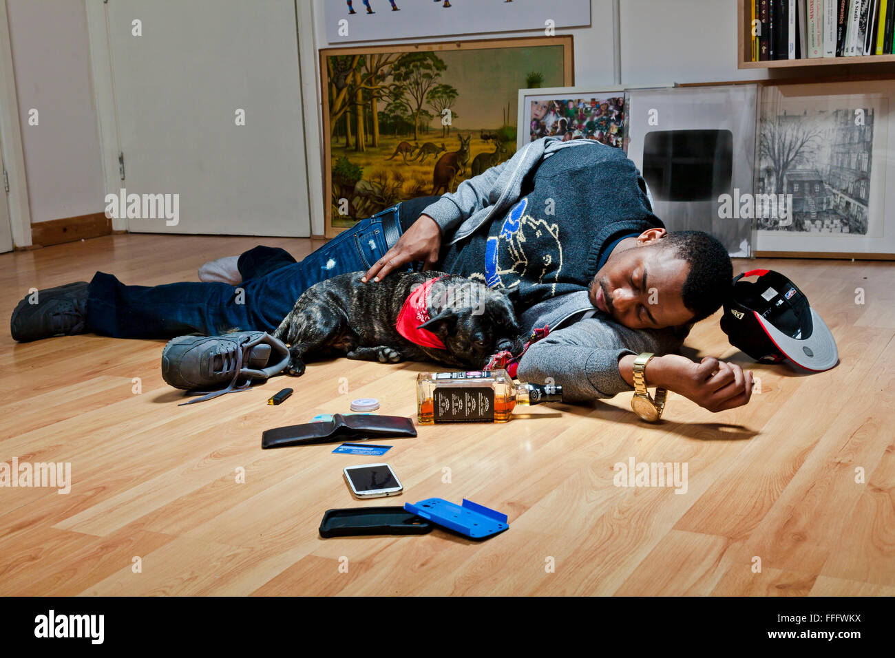 Young man sleeps on floor with a dog leaving a mass. Stock Photo