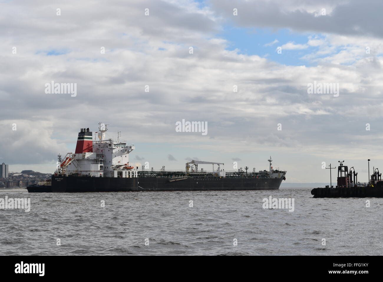 Ship passing Woodside Mersey Ferry Terminal, approaching Birkenhead docks. Stock Photo