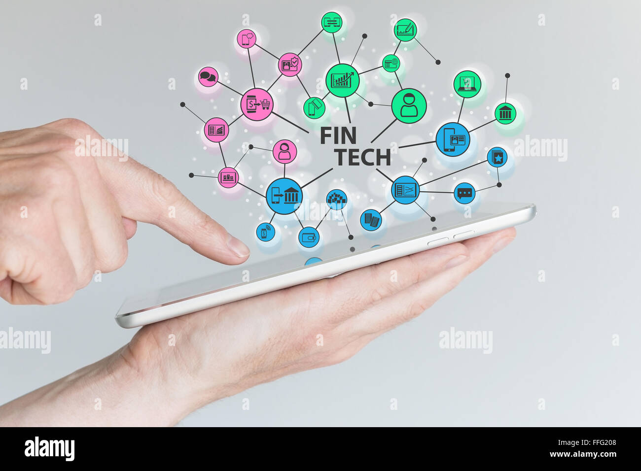 Fin Tech and mobile computing concept. Hand holding tablet with network of financial information technology objects in front of Stock Photo