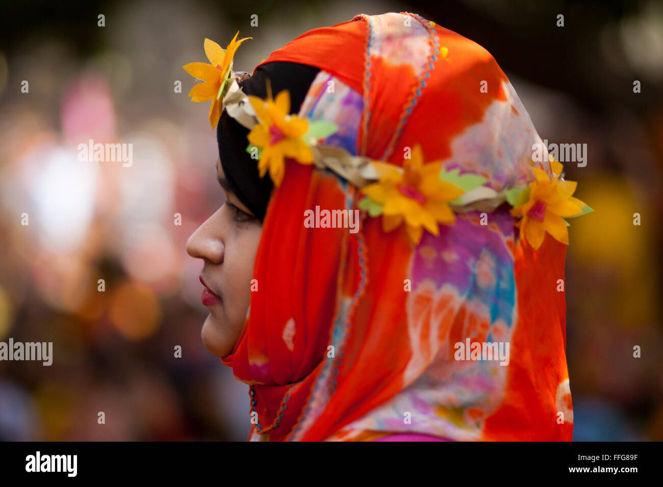 Dhaka, Bangladesh. 13th Feb, 2016. Bangladeshi youths wearing traditional saris and ornate jewellery take part in the 'Basanta Utsab' or spring Festival in Dhaka, Bangladesh on February 13, 2016. The blazing red and yellow are the representative colours of Pohela Falgun. Pohela Falgun, the first day of spring in the Bengali month of Falgun, is being celebrated today with flowers, poems, songs and dances. It brings joys and colours both in nature and life. After the dryness of winter, new leaves start to come out again and the nature adorns the branches with new colorful flowers such as Shimul  Stock Photo