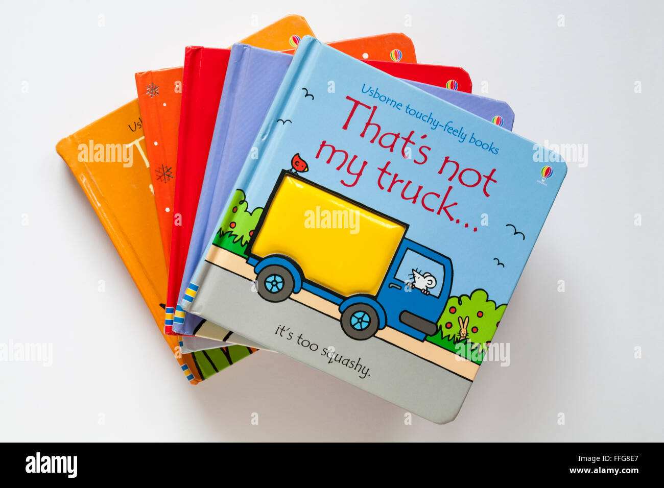 Pile of children's books in That's not my series Usborne touchy-feely books isolated on white background with That's not my truck on top Stock Photo