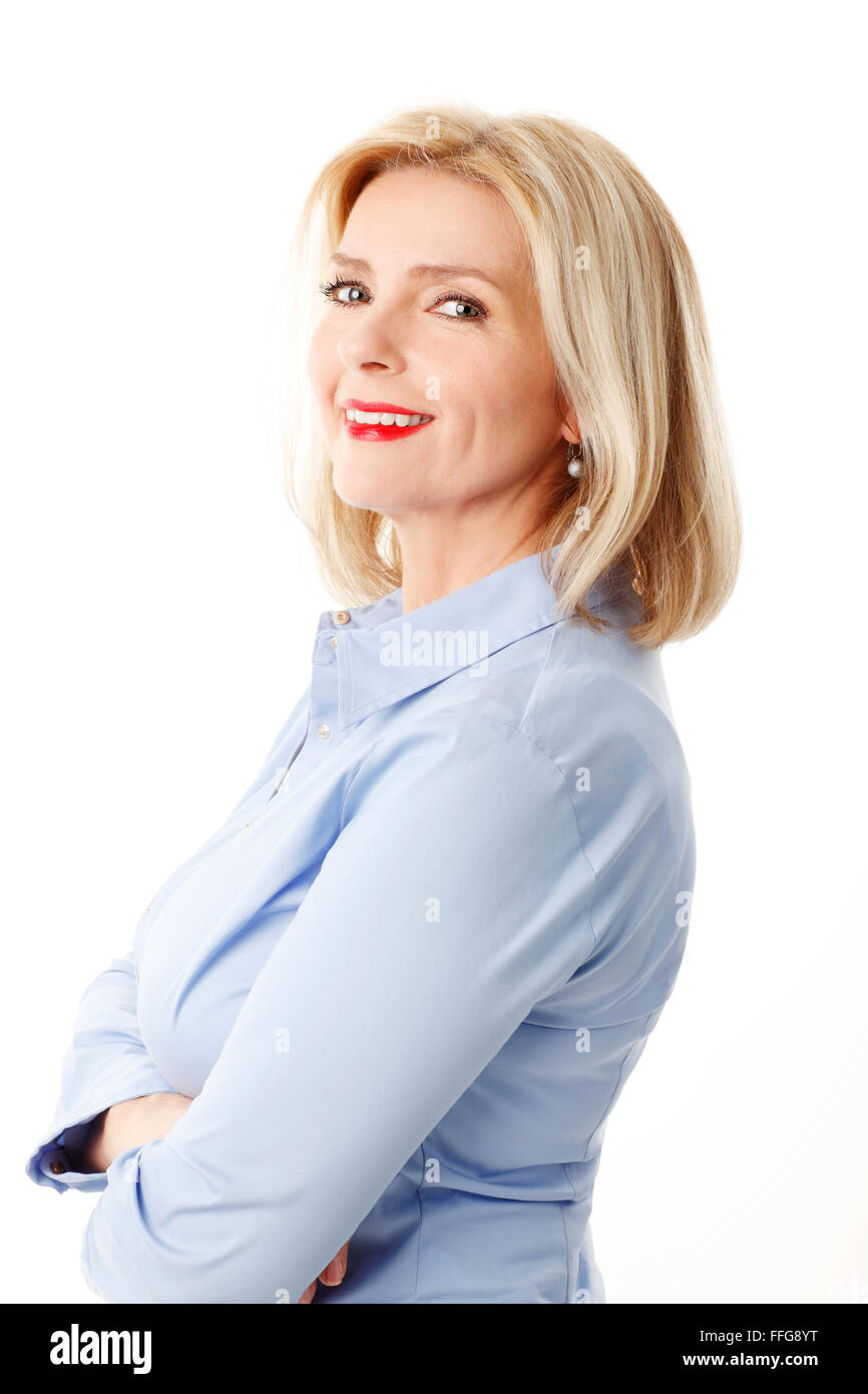 Portrait of attractive middle age woman standing against white background while looking at camera. Stock Photo