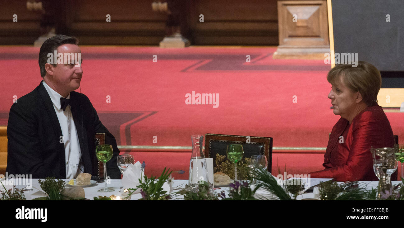 Hamburg, Germany. 12th Feb, 2016. Britain's Prime Minister David Cameron (L-R), and German Chancellor Angela Merkel talk at the annual Matthiae dinner at the city hall of Hamburg, Germany, 12 February 2016. Britain's Prime Minister David Cameron and German Chancellor Angela Merkel are guests of honour at the oldest feast in the world. Since 1356, the leaders of the Hansa city invite distinguished guests to the Matthiae dinner. Photo: LUKAS SCHULZE/dpa/Alamy Live News Stock Photo