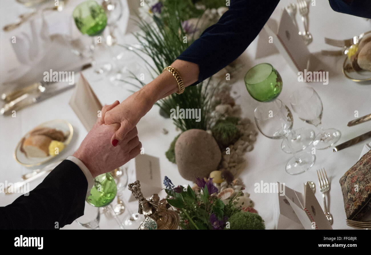 Hamburg, Germany. 12th Feb, 2016. Two guests shake hands as they attend the annual Matthiae dinner at the city hall of Hamburg, Germany, 12 February 2016. Britain's Prime Minister David Cameron and German Chancellor Angela Merkel are guests of honour at the oldest feast in the world. Since 1356, the leaders of the Hansa city invite distinguished guests to the Matthiae dinner. Photo: LUKAS SCHULZE/dpa/Alamy Live News Stock Photo