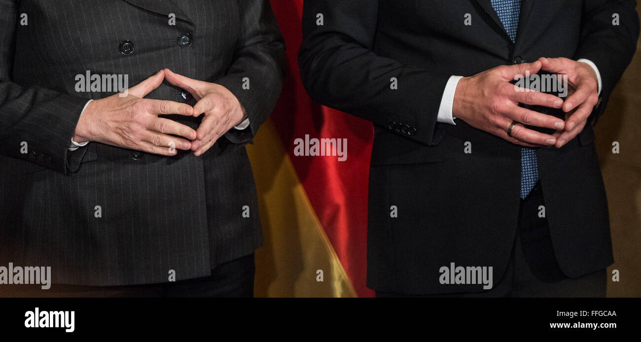 Hamburg, Germany. 12th Feb, 2016. German Chancellor Angela Merkel (L) and Hamburg's First Mayor Olaf Scholz pose with folded hands prior to the annual Matthiae dinner at the city hall of Hamburg, Germany, 12 February 2016. Britain's Prime Minister David Cameron and German Chancellor Angela Merkel are guests of honour at the oldest feast in the world. Since 1356, the leaders of the Hansa city invite distinguished guests to the Matthiae dinner. Photo: LUKAS SCHULZE/dpa/Alamy Live News Stock Photo