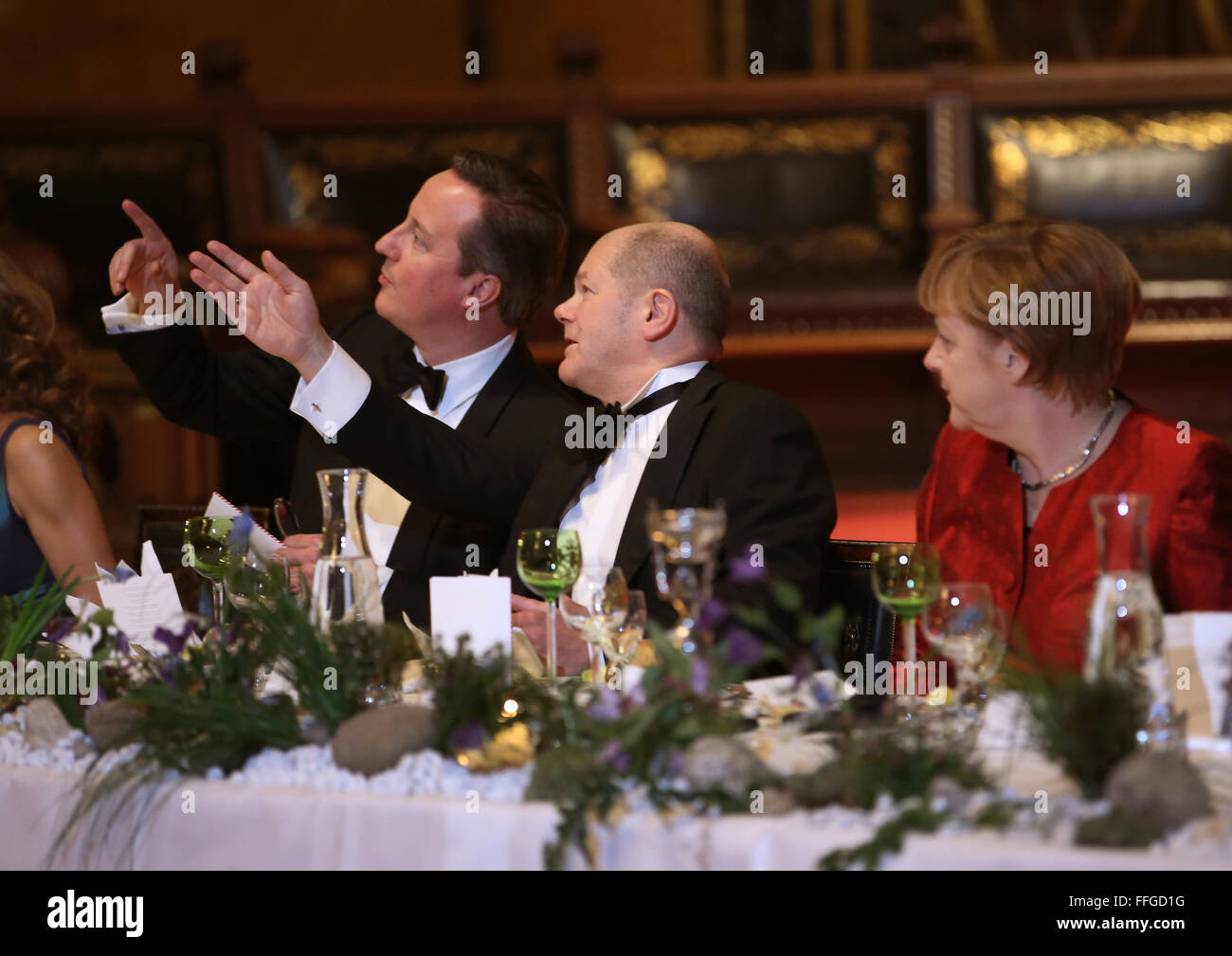 Hamburg, Germany. 12th Feb, 2016. German Chancellor Angela Merkel (R-L), Hamburg's First Mayor Olaf Scholz and Britain's Prime Minister David Cameron talk at the annual Matthiae dinner at the city hall of Hamburg, Germany, 12 February 2016. Britain's Prime Minister David Cameron and German Chancellor Angela Merkel are guests of honour at the oldest feast in the world. Since 1356, the leaders of the Hansa city invite distinguished guests to the Matthiae dinner. Photo: CHRISTIAN CHARISIUS/dpa/Alamy Live News Stock Photo