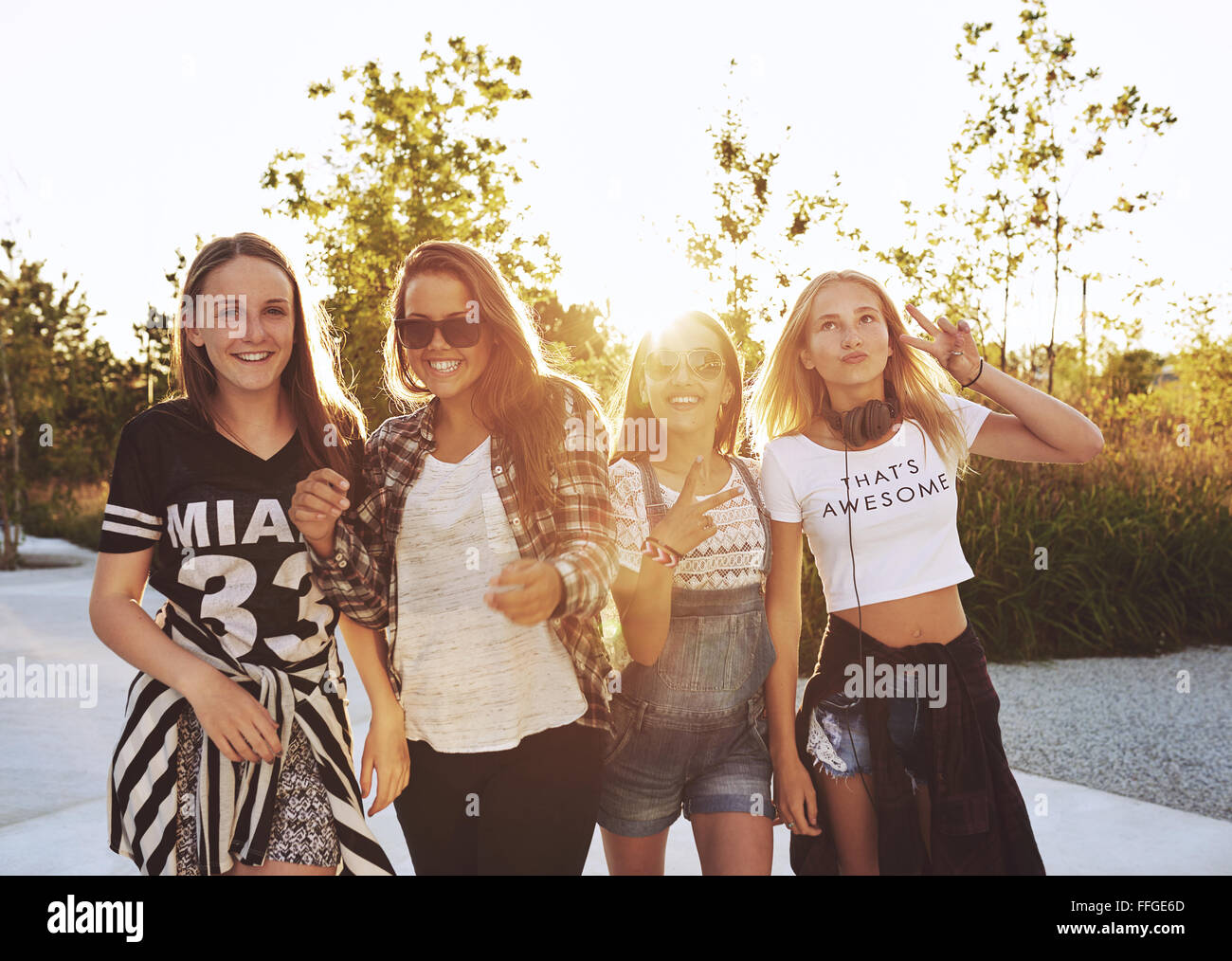 Group of girls laughing and posing, outside on a summer day, sun flare Stock Photo