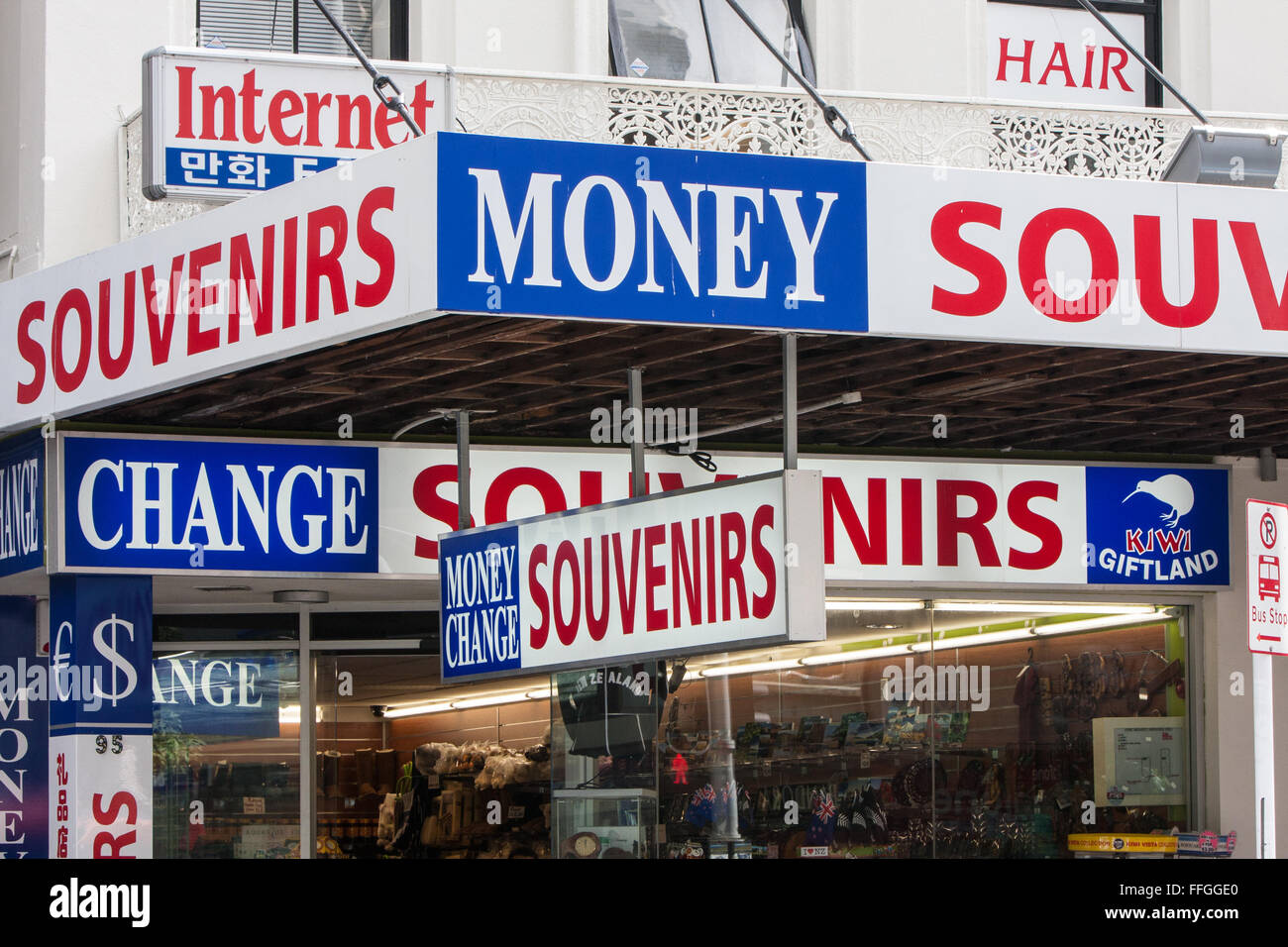Currency exchange and souvenir signage outside shop on Queen Street in