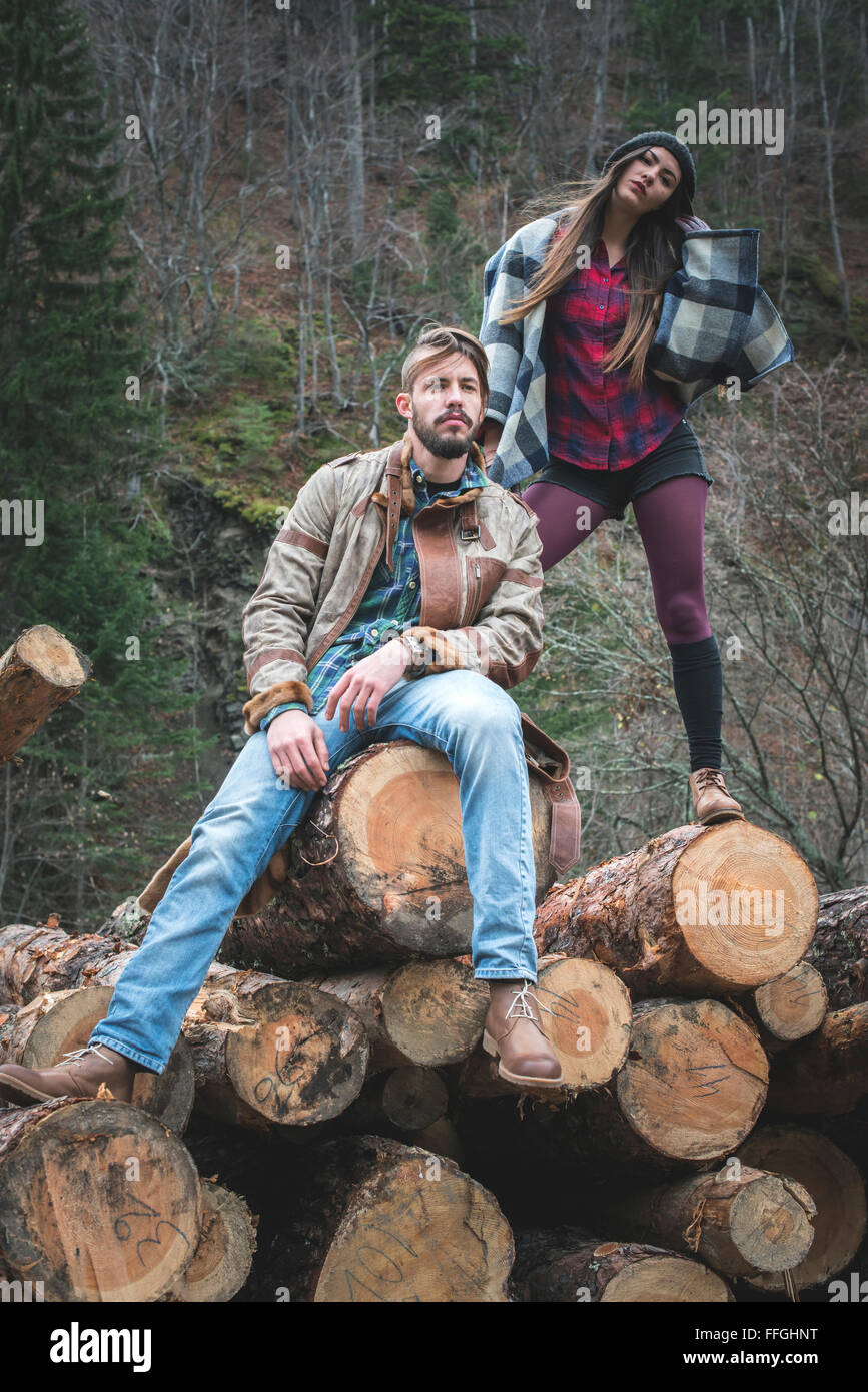Young woman and men on wood logs in the forest Stock Photo - Alamy