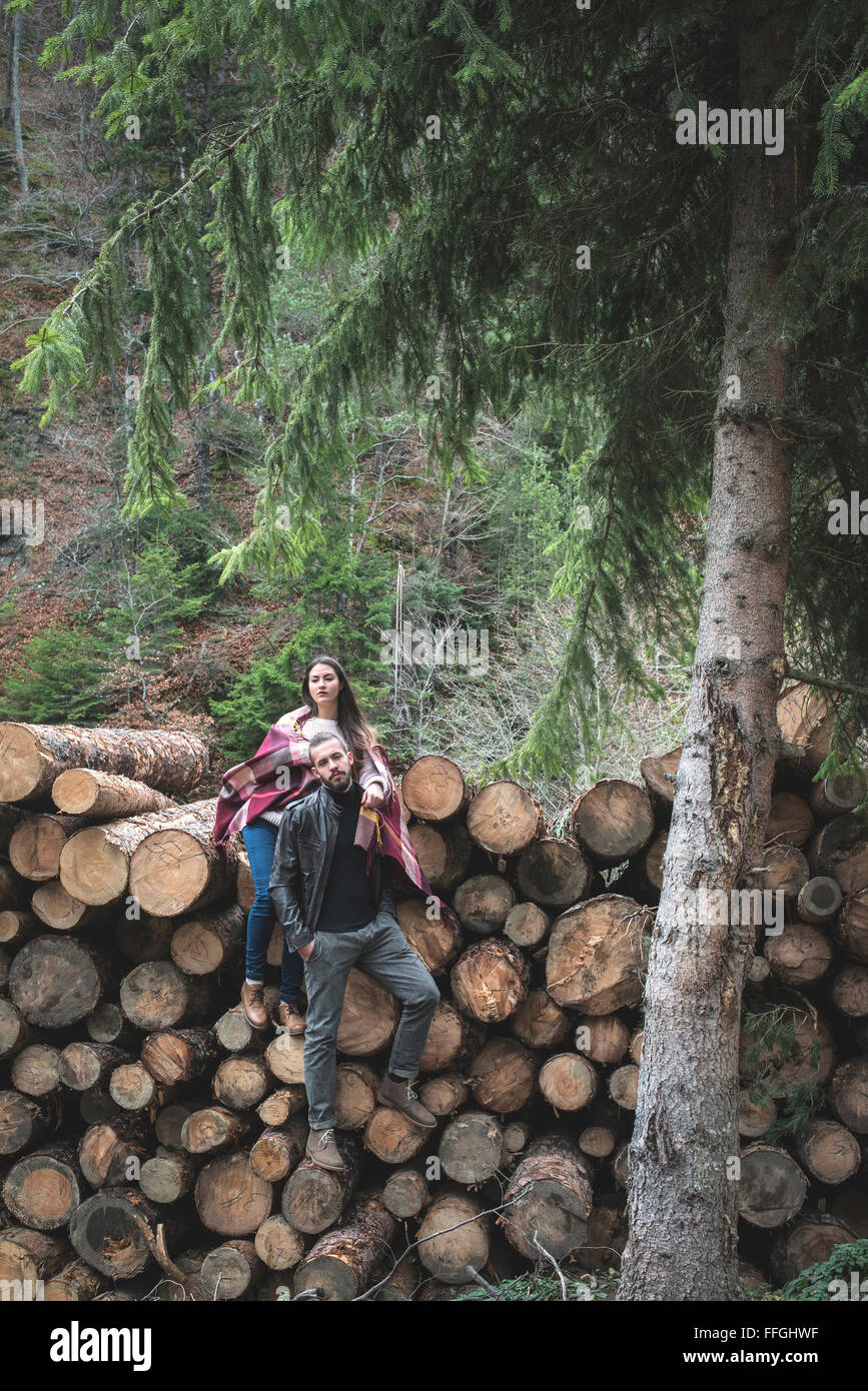 Young woman and men on wood logs in the forest Stock Photo - Alamy