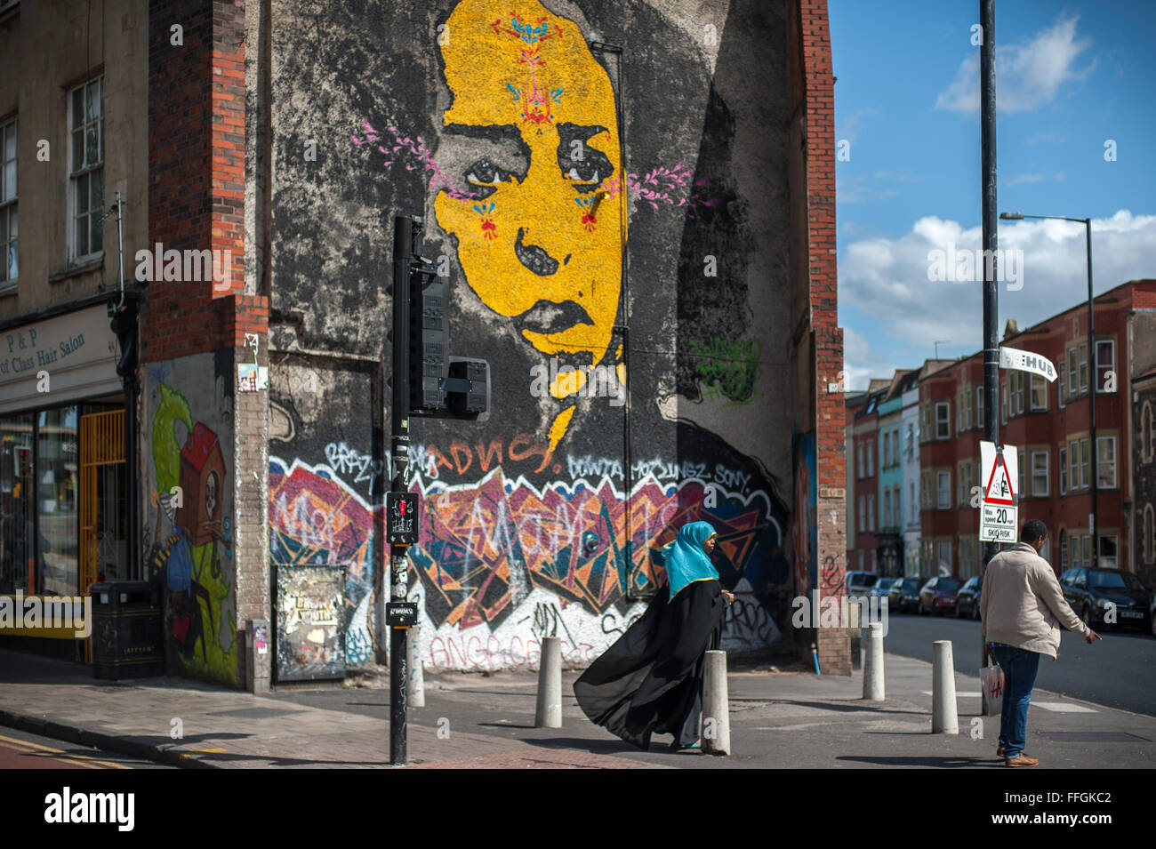 Muslim Somali couple and urban street art mural, Stokes Croft, Bristol, England Stock Photo