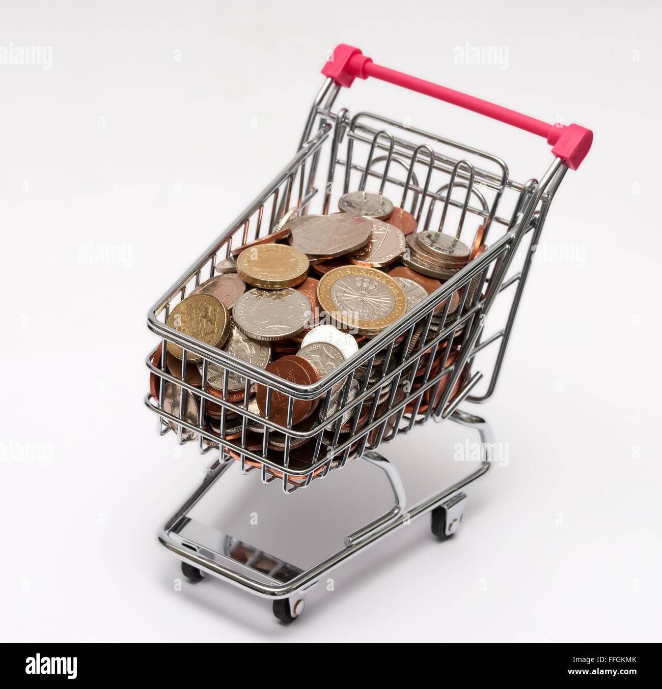 Small supermarket shopping trolley with coins inside. Cost of living