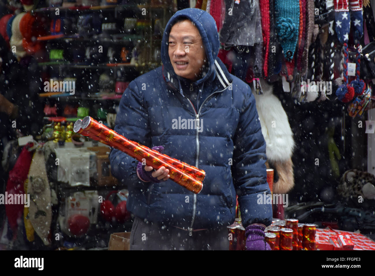 A Chinese businessman selling confetti blowers in the snow for the Chinese New Year's Parade. On Mott Street in Chinatown, NYC Stock Photo