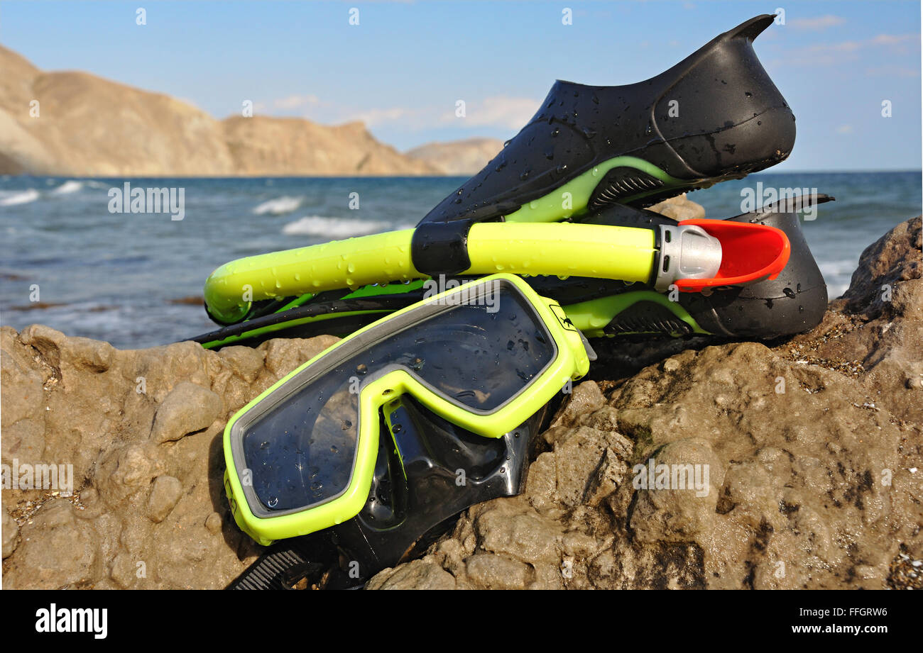 Flippers, snorkel and diving mask on seacoast. Stock Photo