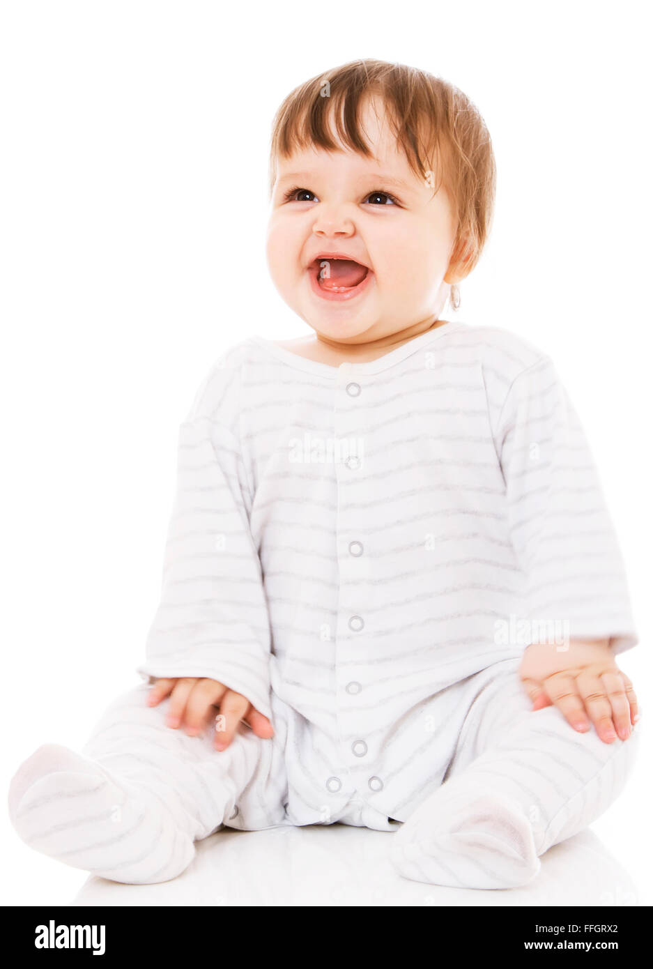 Cute baby sitting on the white floor background, wearing a sliders and smiling big. Isolated. Stock Photo
