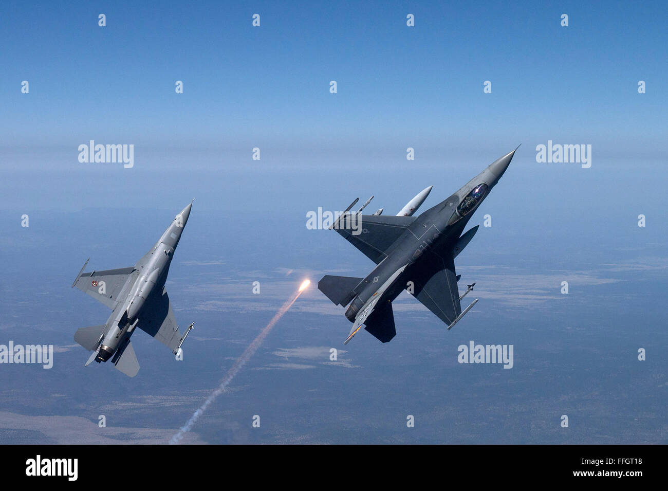 F-16 Fighting Falcons from the 162nd Wing, Tucson, Arizona fly over an training range on April 8, 2015. The 161st Wing manages a fleet of more than 70 F-16 C/D and Mid-Life Update Fighting Falcons. There are three flying squadrons and numerous maintenance units assigned to the wing. Stock Photo