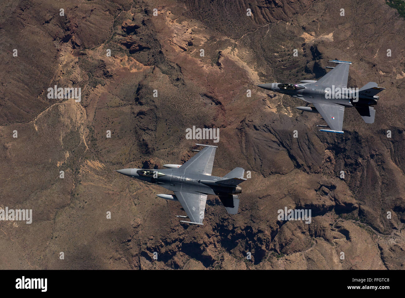 F-16 Fighting Falcons from the 162nd Wing, Tucson, Arizona fly over an training range on April 8, 2015. The 161st Wing manages a fleet of more than 70 F-16 C/D and Mid-Life Update Fighting Falcons. There are three flying squadrons and numerous maintenance units assigned to the wing. Stock Photo