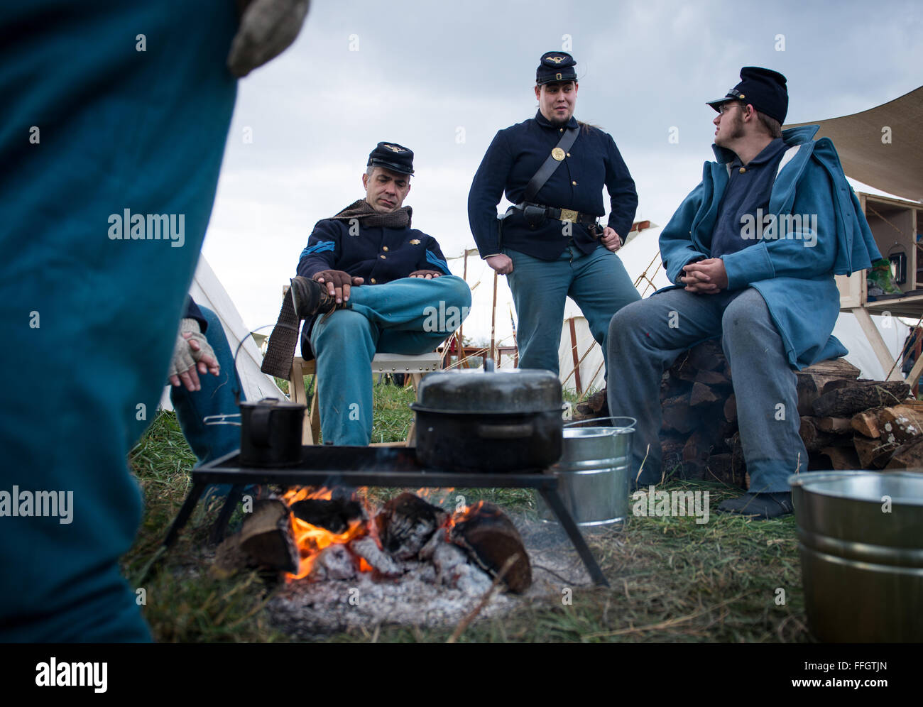 Pvt. Joshua Withrow (middle) and other members of the Union provost take moment to warm by the fire and talk about previous re-enactments they've attended. Joshua got into re-enactments with his father when they attended an event in 2000. Stock Photo