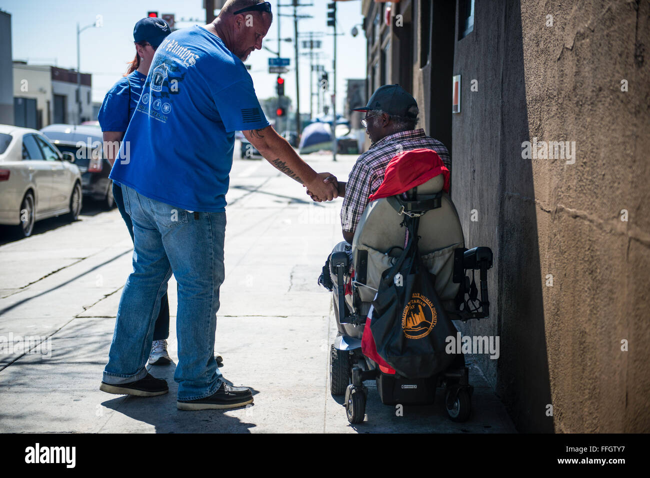 Vet Hunter Travis Goforth thanks and shakes the hand of a homeless man after getting details of the whereabouts of other homeless veterans on Skid Row. Skid Row is a 54-block area of Los Angeles with thousands of homeless individuals Stock Photo