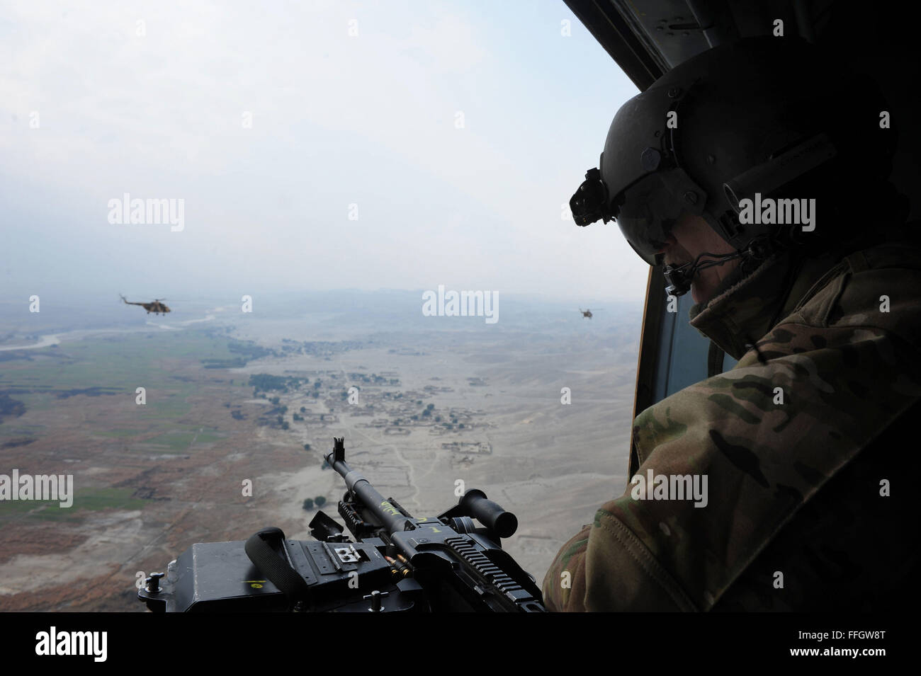 Senior Master Sgt. Todd Peplow, an aerial gunner with the 438th Air Expeditionary Advisory Squadron, provides gunner support on an Afghan air force MI-17 during a flight over Afghanistan. Peplow is currently deployed to provide advisory training for AAF flight engineers at Kabul International Airport. Stock Photo