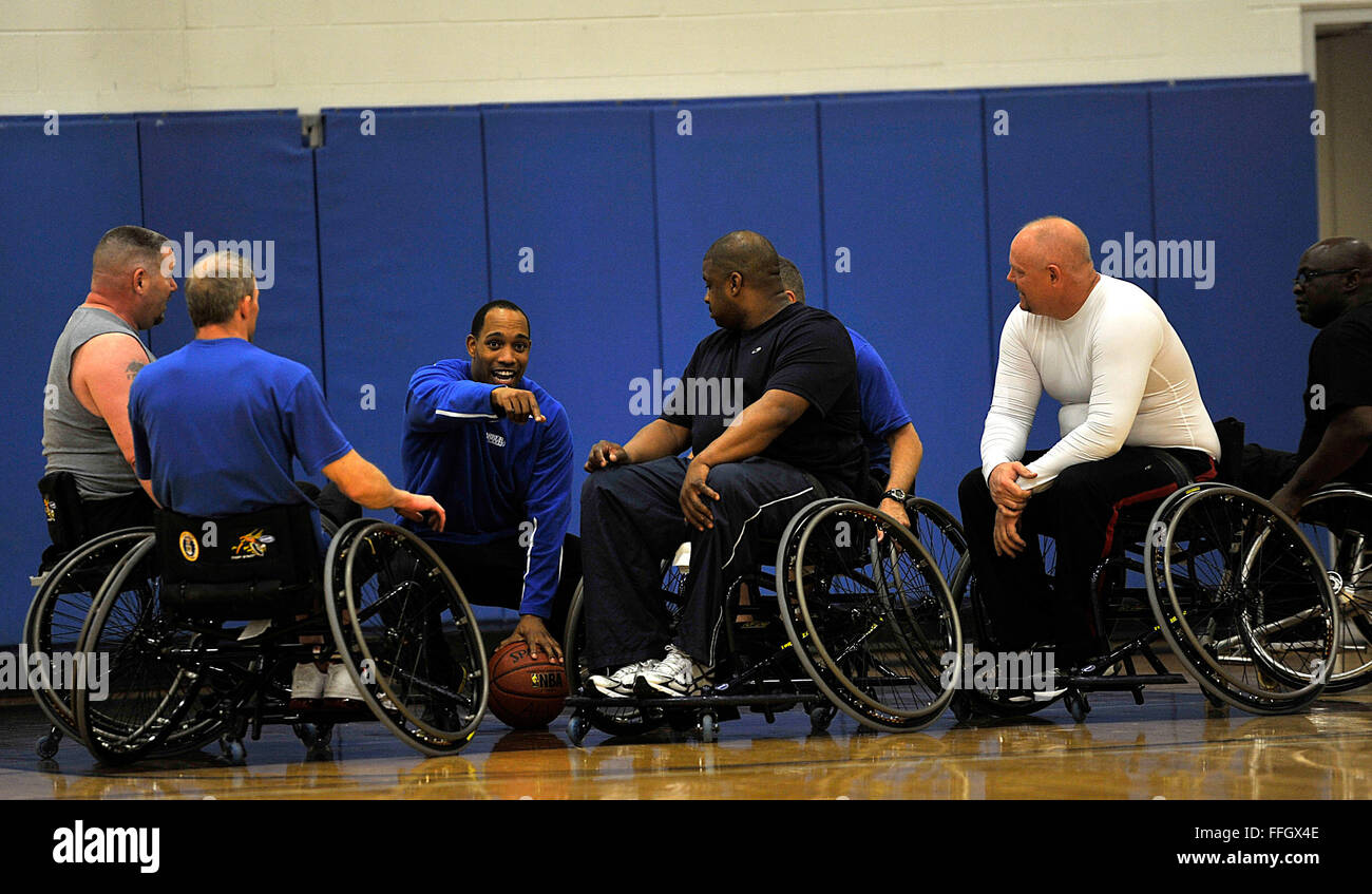 Wheelchair basketball athletes take instuctions from their coach while