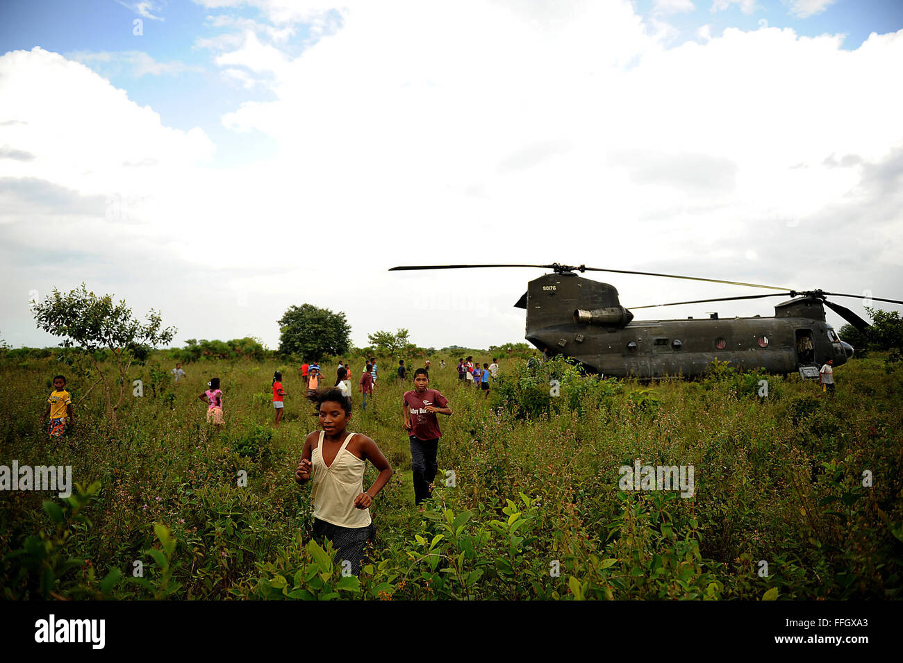 Local children from the village of Wawina, Honduras, scatter before the engines of a CH-47 Chinook fire up and take the U.S. military members from the Joint Task Force-Bravo Medical Element back to Soto Cano Air Base. Stock Photo