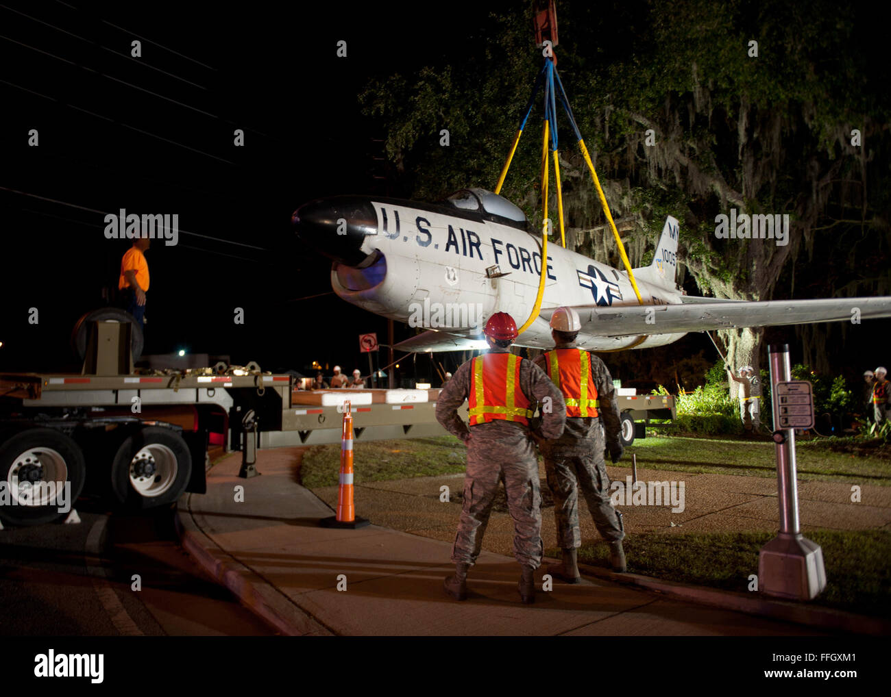 Airmen from Moody Air Force Base, Ga., look on as an F-86L Sabre is lifted off its mount by a crane and placed on a flatbed trailer for transport to the base. A rededication ceremony will take place in the future to commemorate the late Maj. Lyn McIntosh and to represent the heritage of the Flying Tigers at the George W. Bush Air Park at Moody Field. Stock Photo