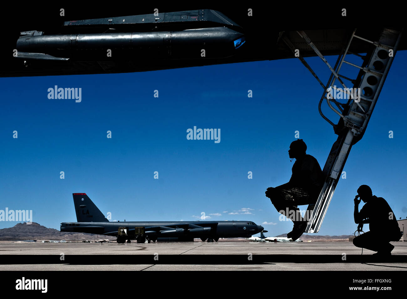 Air Force maintainers wait for a B-1B Lancer to launch during Red Flag 12-4 at Nellis AFB. The B-1B carries the largest payload of both guided and unguided weapons in the U.S. Air Force's inventory. The Airmen are assigned to the 28th Maintenance Squadron at Ellsworth AFB, S.D. Stock Photo