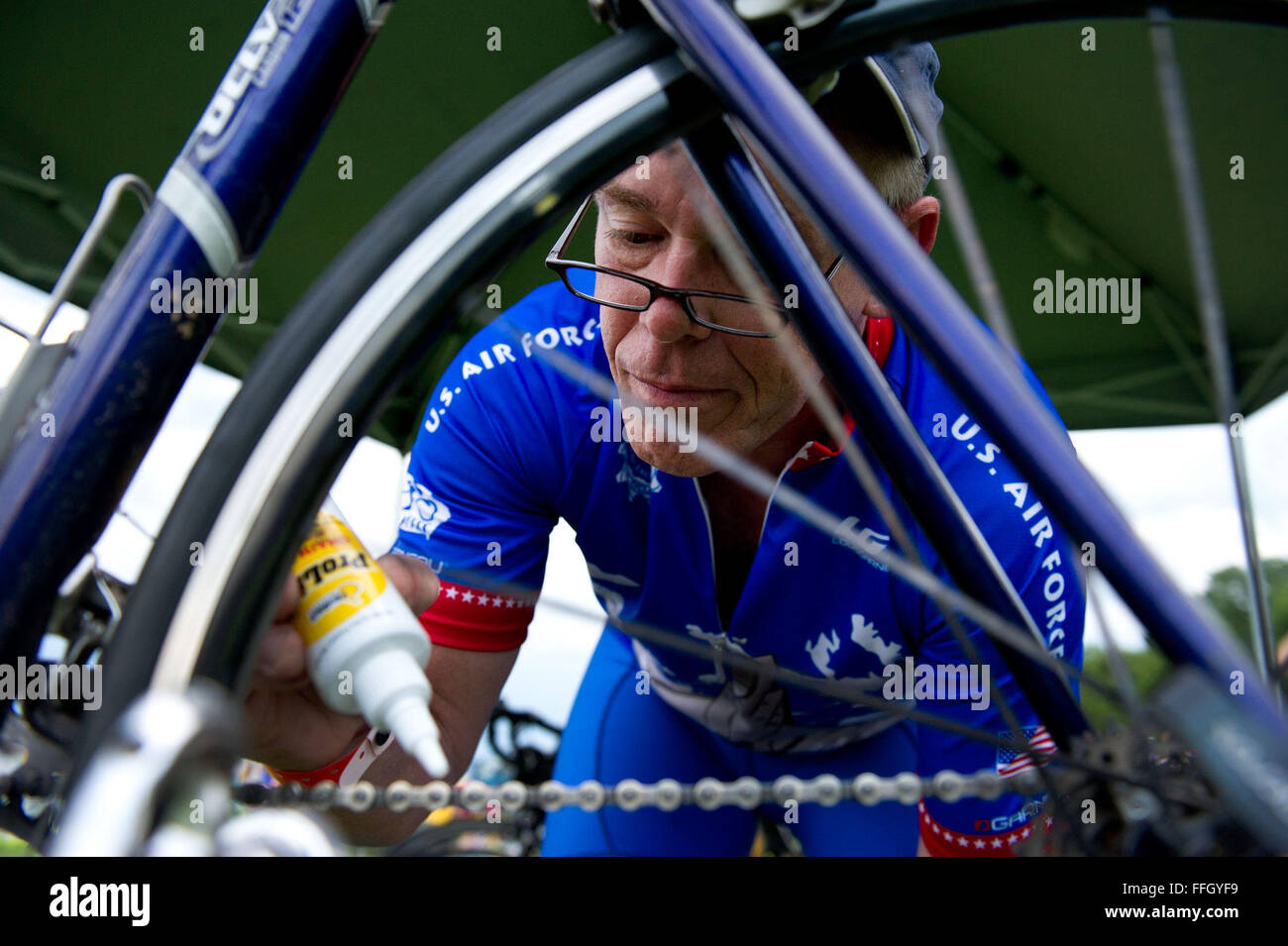 Ron Phipps lubes his chain before the first day of riding in the RAGBRAI in Sioux Center, Iowa. Phipps has been on the RAGBRAI Air Force Cycle Team for 12 years and said proper bike maintenance is essential to prevent breakdowns throughout the week. Phipps is an instructor at the Air Force Institute of Technology at Wright Patterson Air Force Base, Ohio. Stock Photo
