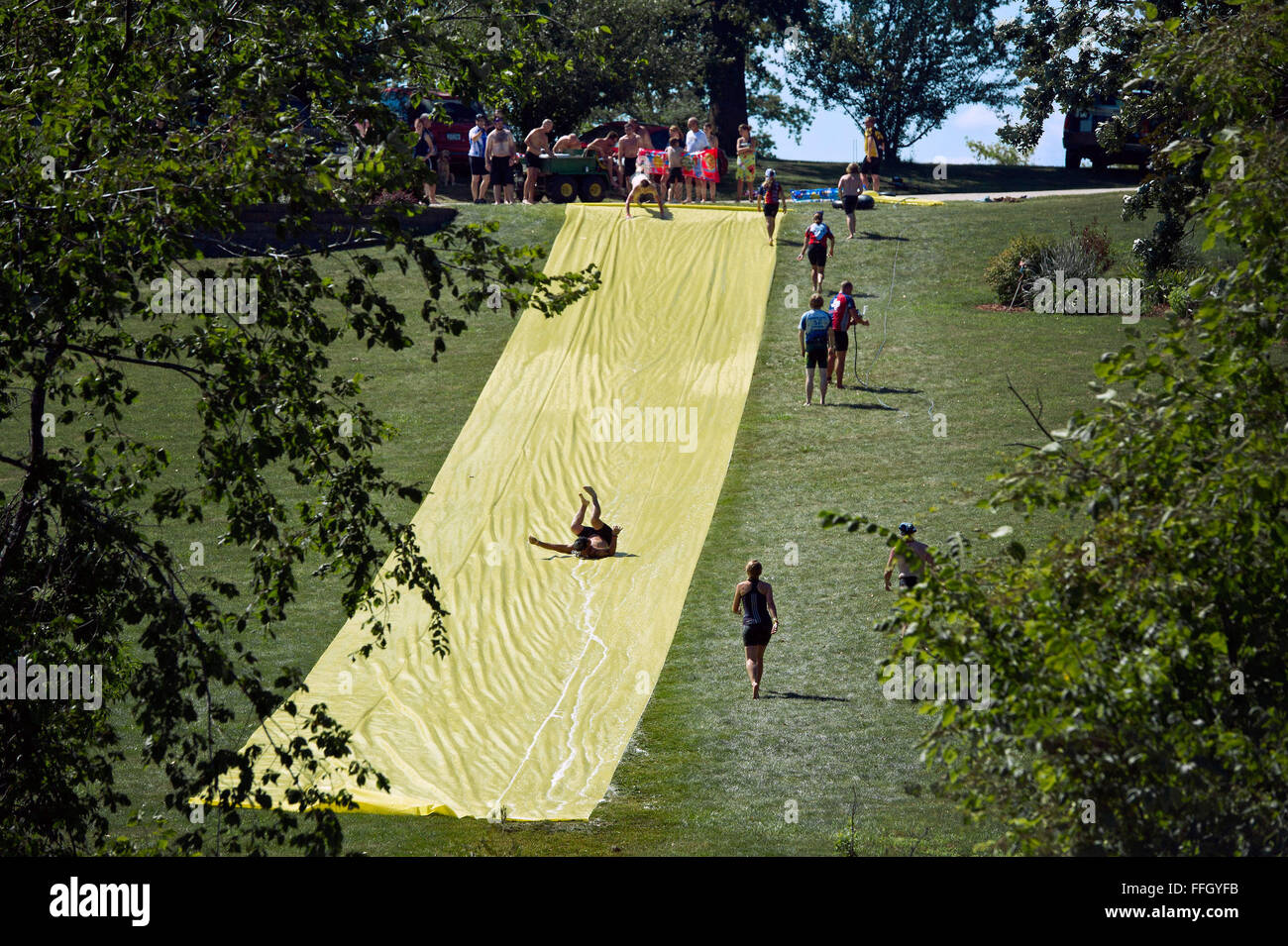 RAGBRAI participants stop at a giant makeshift water slide along the route from Cedar Rapids to Anamosa, Iowa. It’s not all about cycling at RAGBRAI but also having fun and meeting new people. Stock Photo