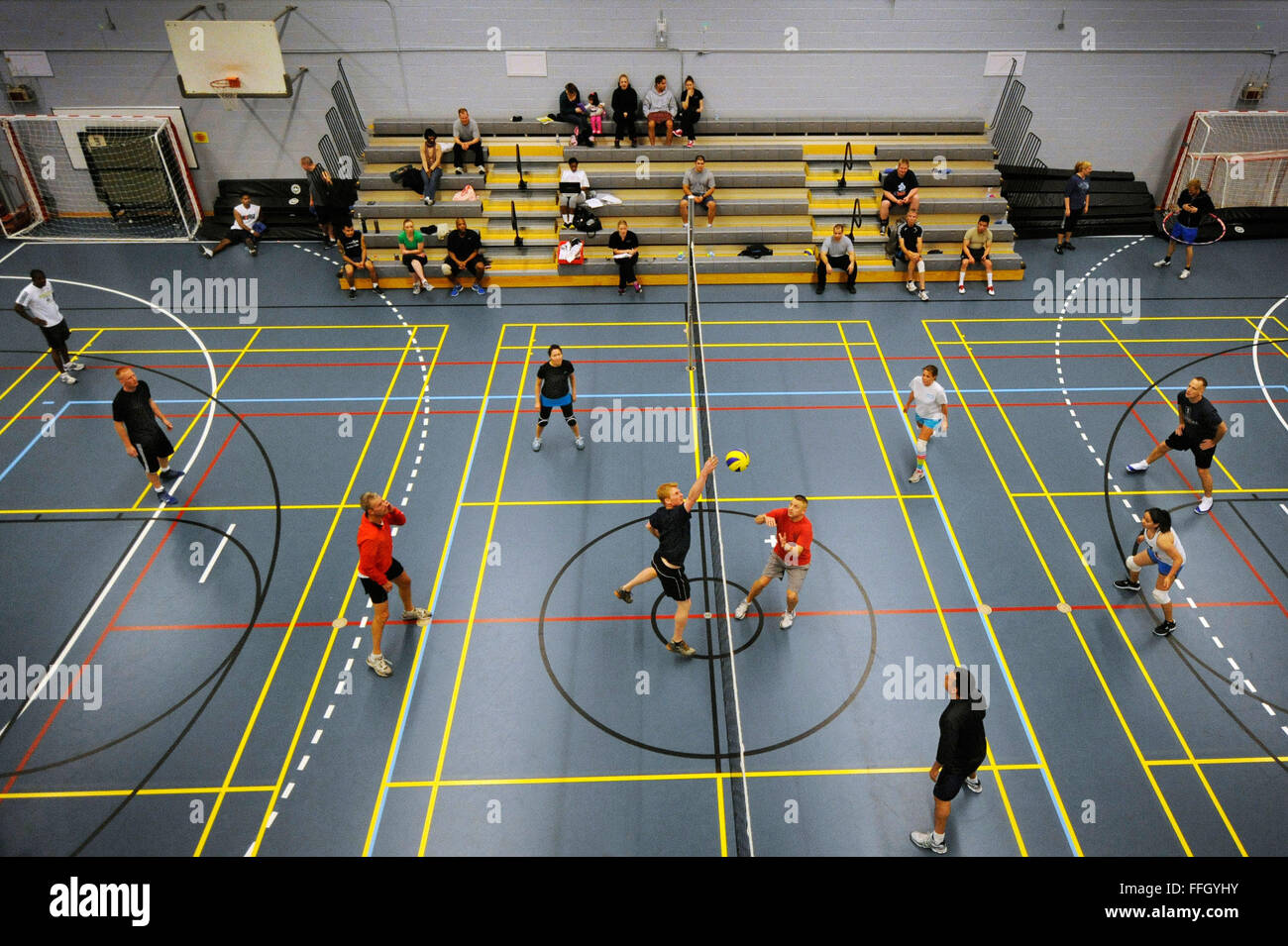 Airmen and Danish contractors participate in a volleyball tournament at the Thule AB gym. Stock Photo