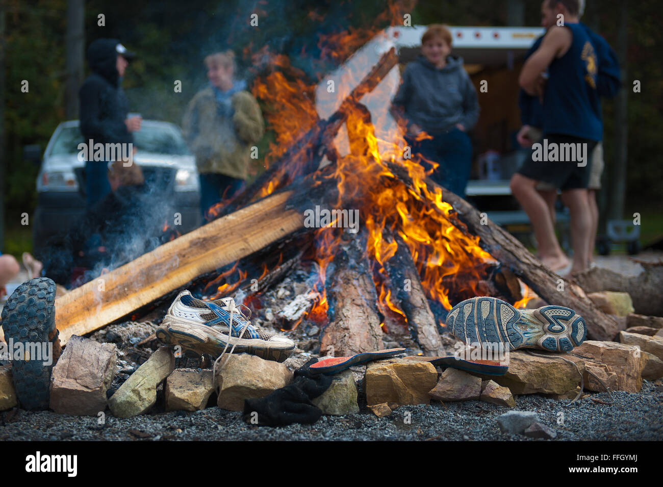 In an attempt to warm up and dry their gear, members placed their soggy shoes by the camp fire after soaking them in a race with cold rapids and muddy trails. Stock Photo