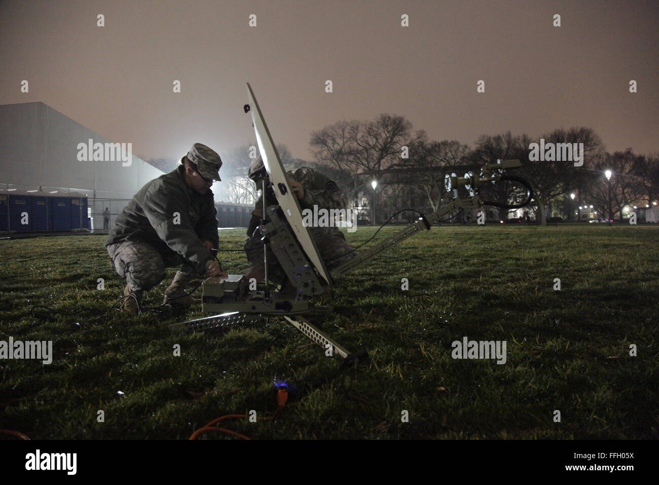 Army National Guard Sgts. Breeanna Pierce (left) and Michael Dann assemble a portable satellite transmitter during a dress rehearsal of the presidential inaugural parade in Washington D.C. The satellite allows news agencies to receive images and video during the 57th Presidential Inauguration. Stock Photo