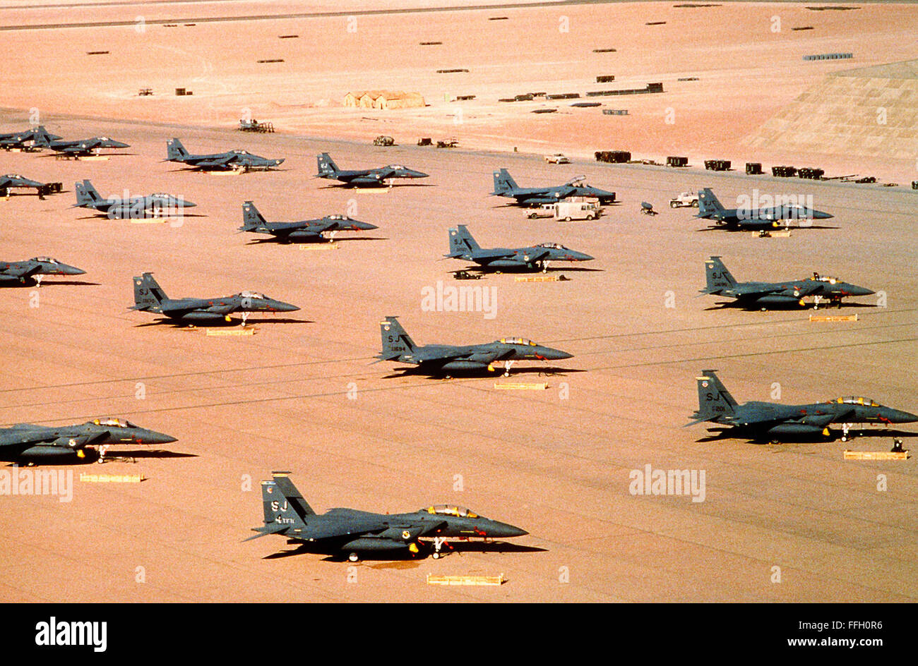 F-15E Eagle fighter aircraft of the 4th Tactical Fighter Wing, Seymour Johnson Air Force Base, N.C., are parked on an air field during Operation Desert Shield.     Deutsch: F-15E Eagle fighter aircraft of the 4th Tactical Fighter Wing, Seymour Johnson Air Force Base, N.C., are parked on an air field during Operation Desert Shield. Stock Photo