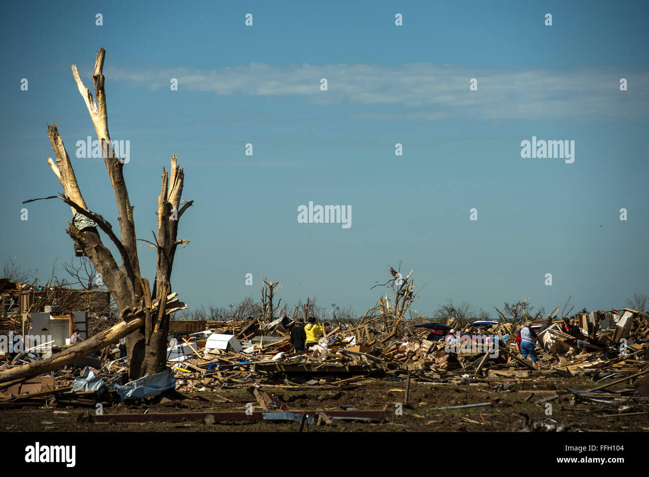 Residents in Moore, Okla. search through the debris where their homes once stood looking for salvageable items May 22, 2013. On Monday a EF-5 tornado, with winds reaching at least 200 mph, traveled for 20 miles, leaving a two-mile-wide path of destruction, leveling homes, crushing vehicles, and killing more than 20 people. More than 115 Oklahoma National Guard have been activated to assist in the rescue and relief efforts. Stock Photo